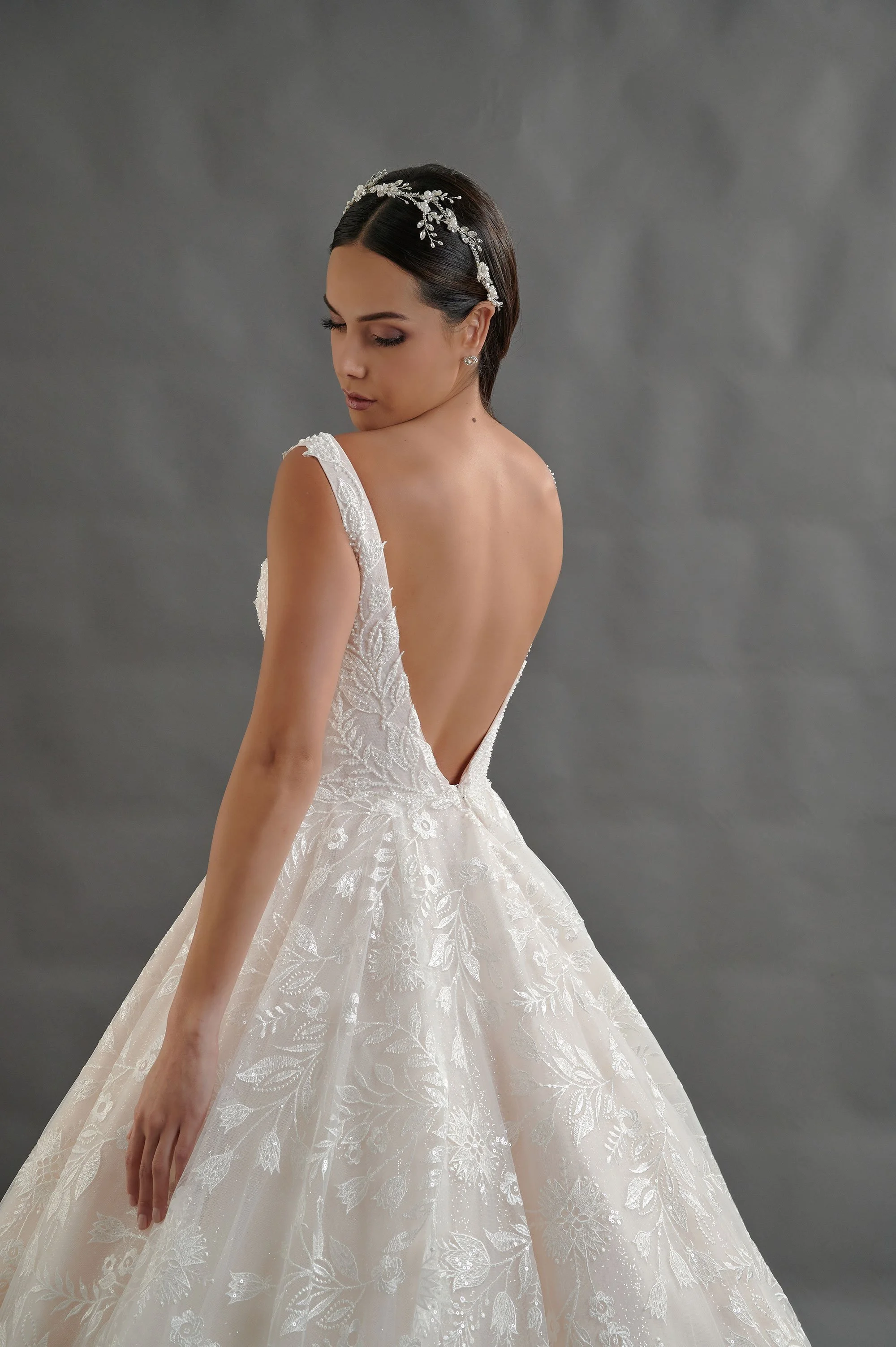 Novia con el vestido Barack de Bridenformal, princesa cubierta de encaje floral bordado y escote en V, vista frontal con cola.