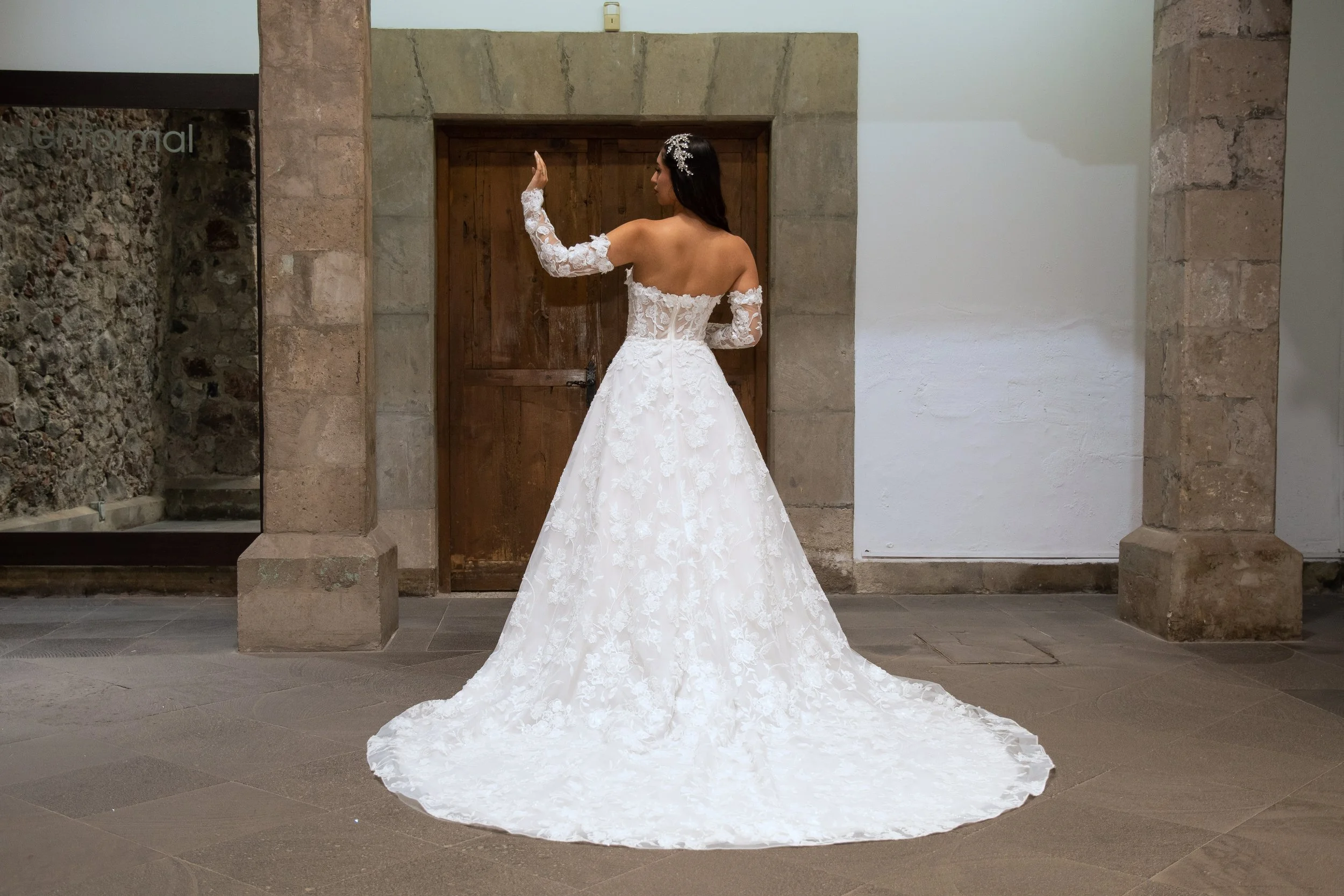 Vista de tres cuartos de la espalda del vestido Lucas con la cola extendida.