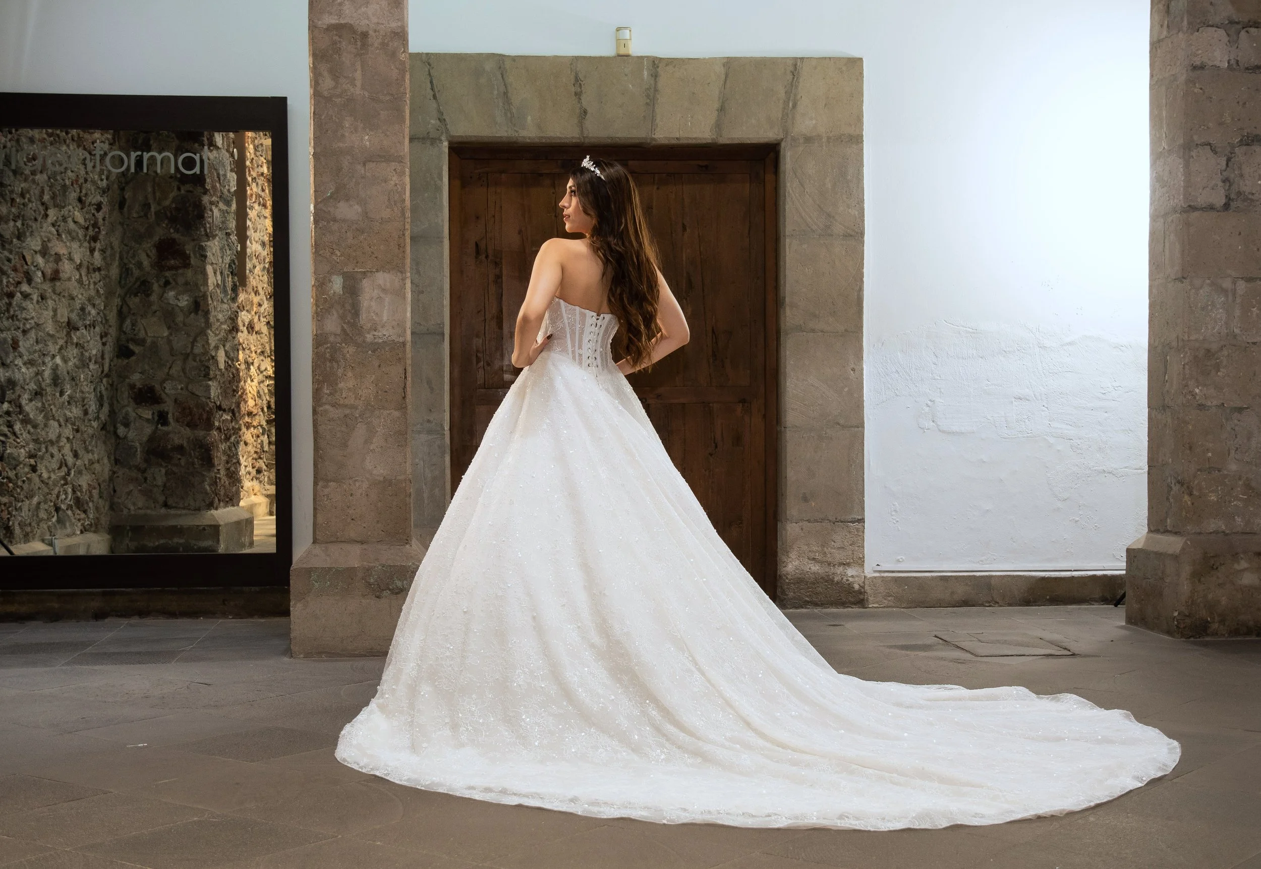 Vista de tres cuartos del vestido Lorelain con la cola de brillo extendida.