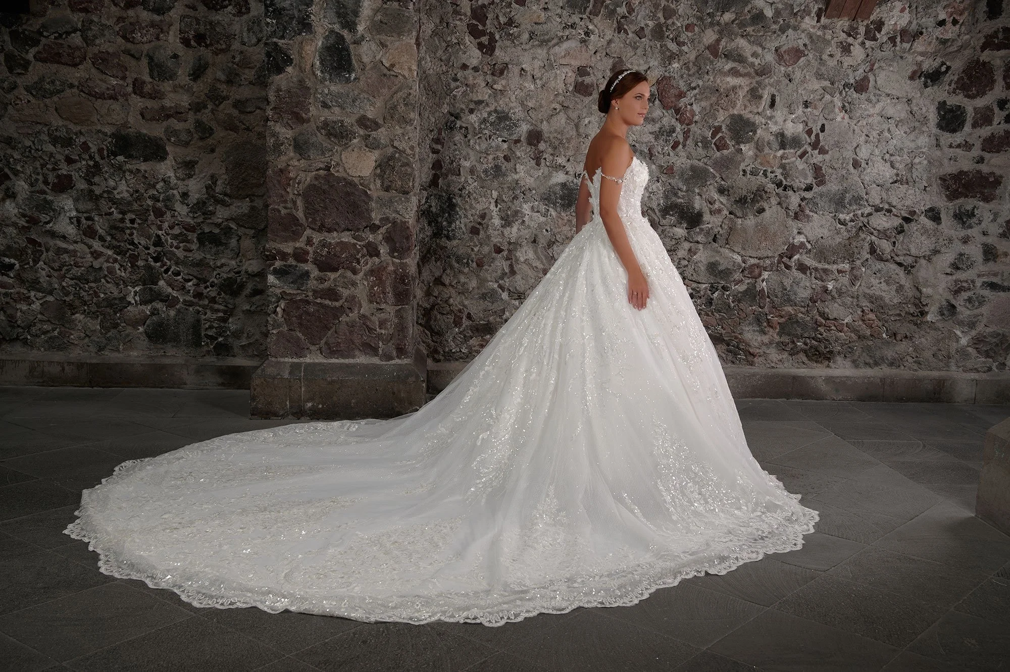 Vista lateral del vestido de novia Casiano mostrando el volumen de la falda de tul y la cola larga.