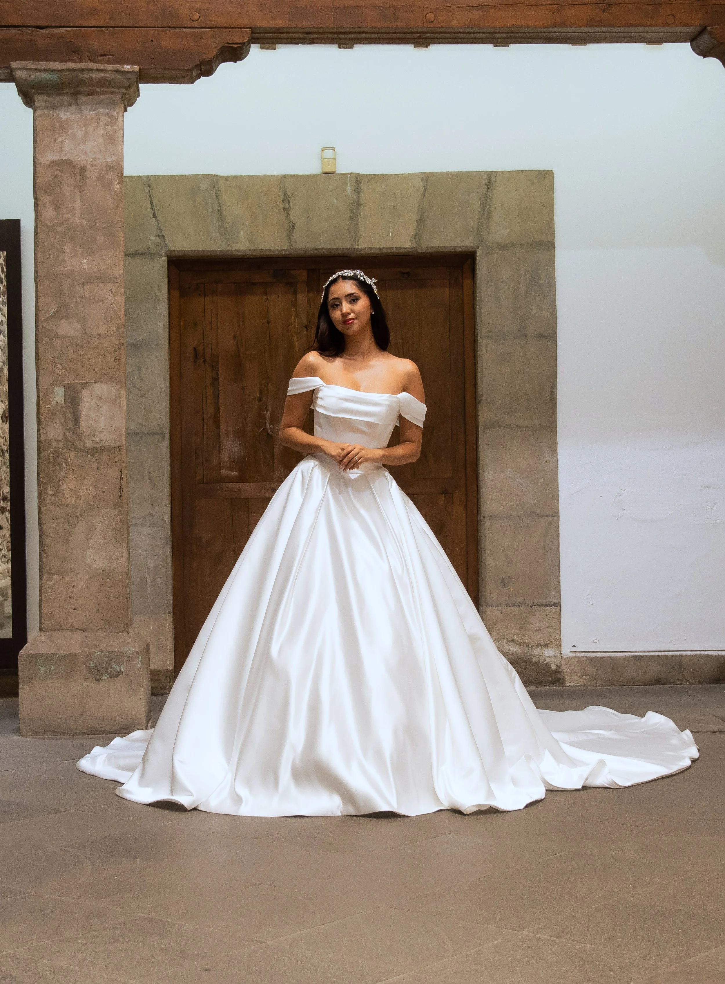 Novia con el vestido Murcia de Bridenformal, princesa de satén con escote bardot, vista frontal completa.