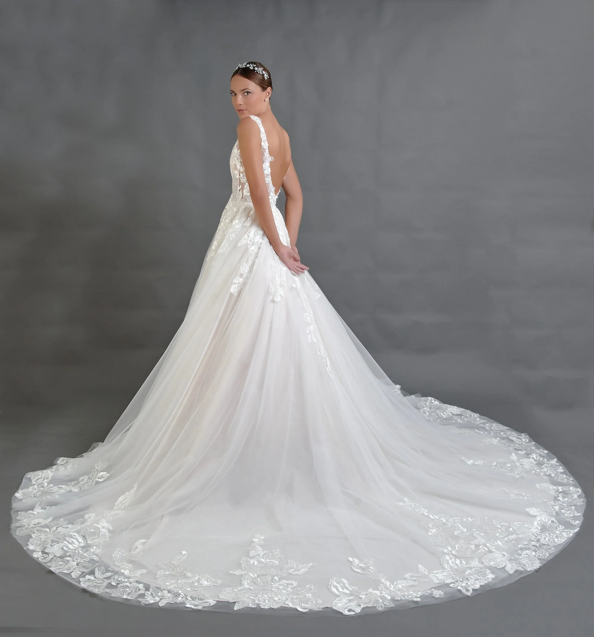 Espalda del vestido de novia Bernona con escote profundo en V y falda de tul con cola larga.