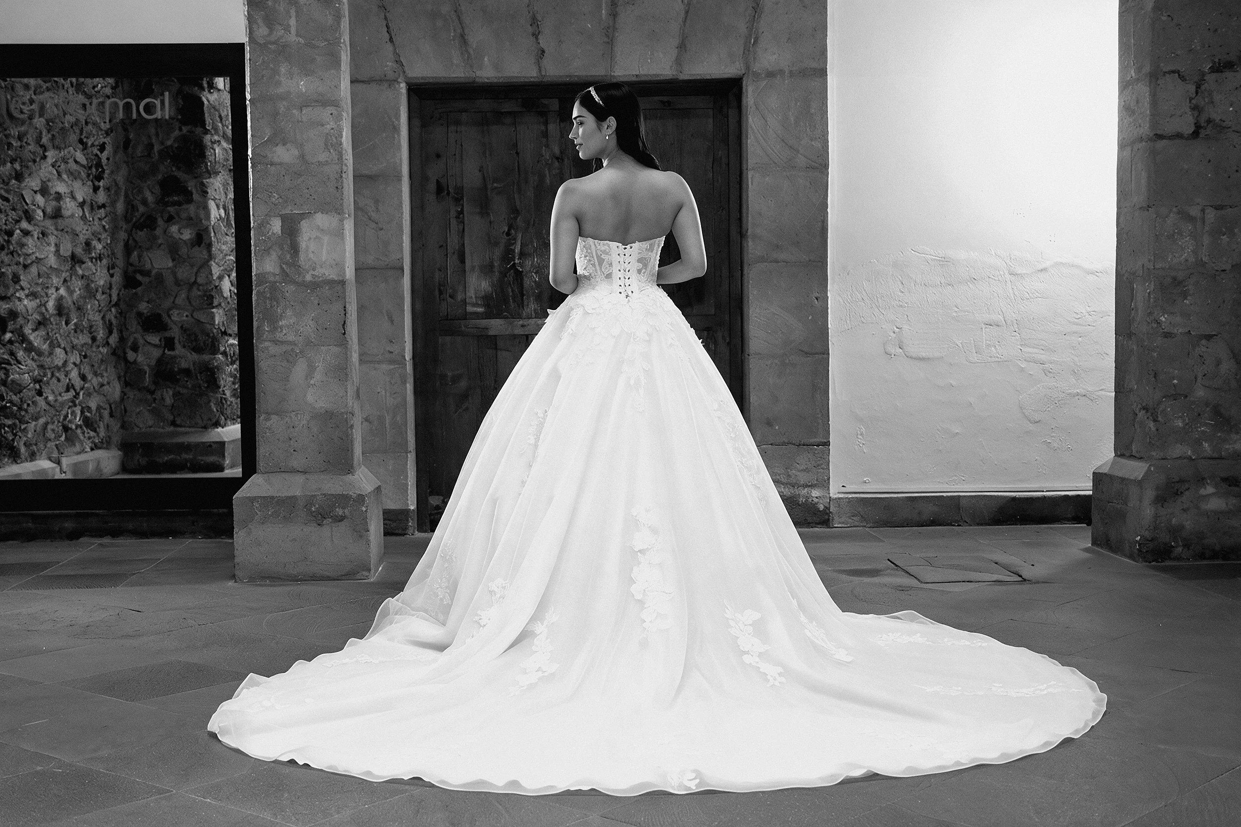 Espalda del vestido de novia Larisa con falda de tul y encaje y cola larga.