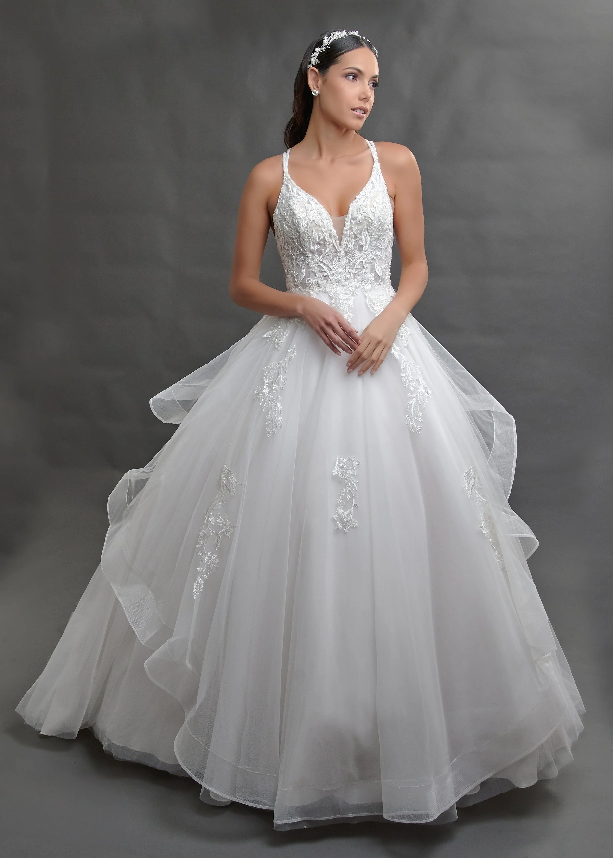 Novia con el vestido Baiona de Bridenformal, princesa de tul en capas con encaje y escote en V, vista frontal con cola.