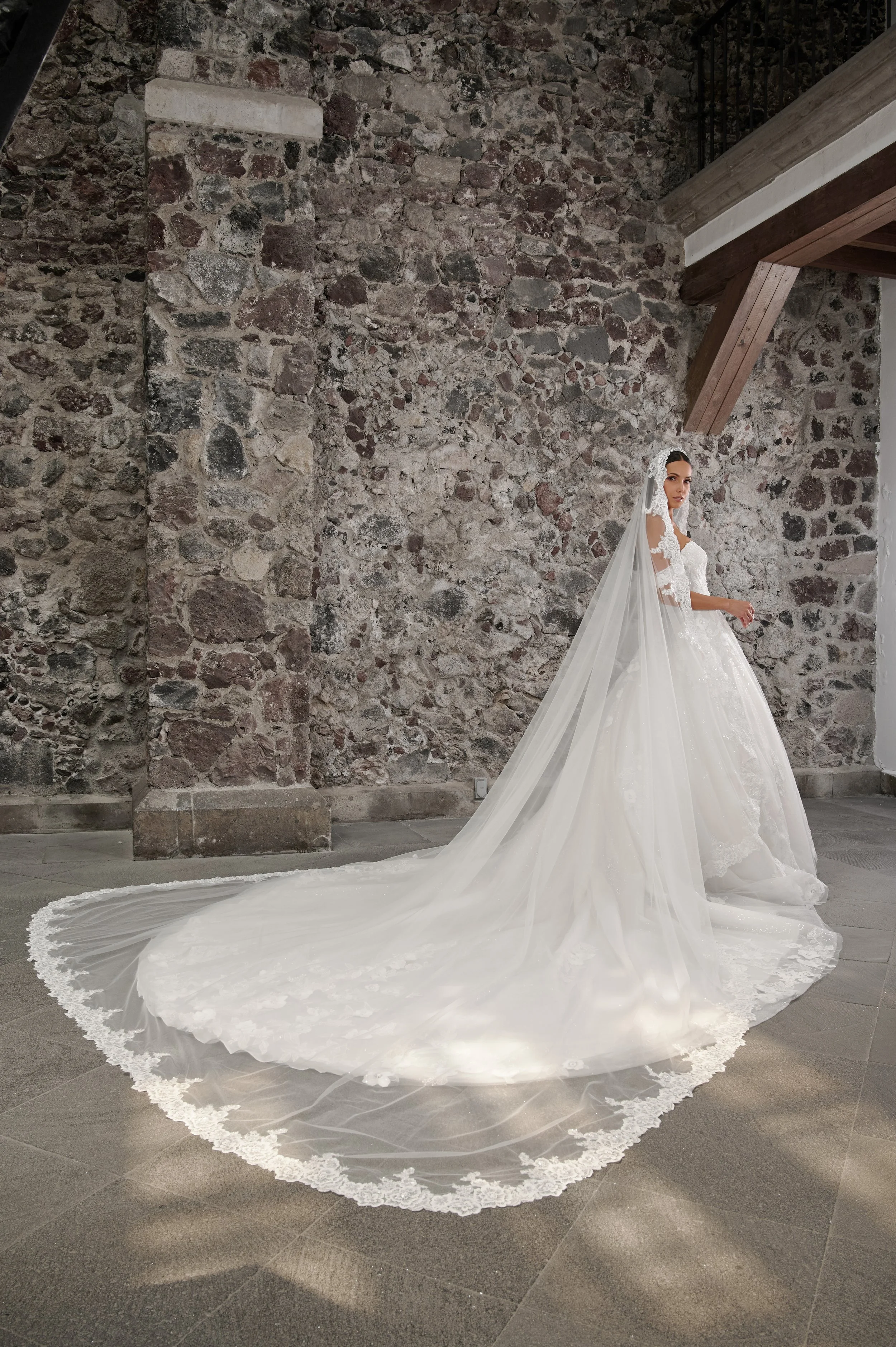 Novia con el vestido Carina de Bridenformal combinado con velo largo de encaje.
