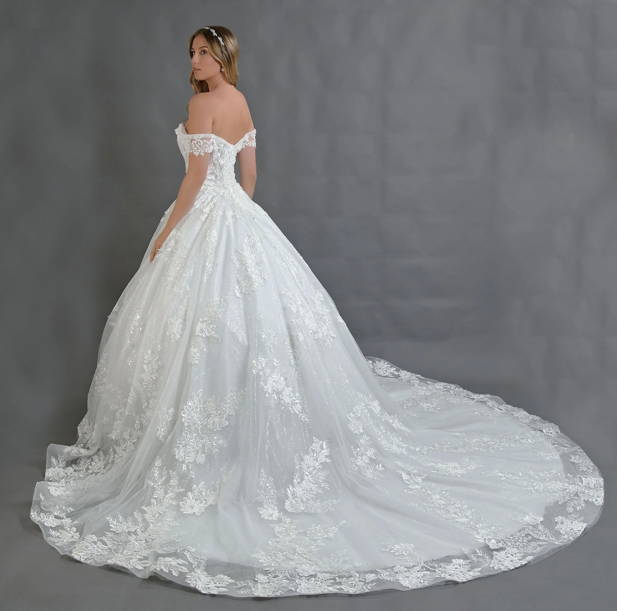 Espalda del vestido de novia Bertino con falda princesa de encaje y cola larga festoneada.