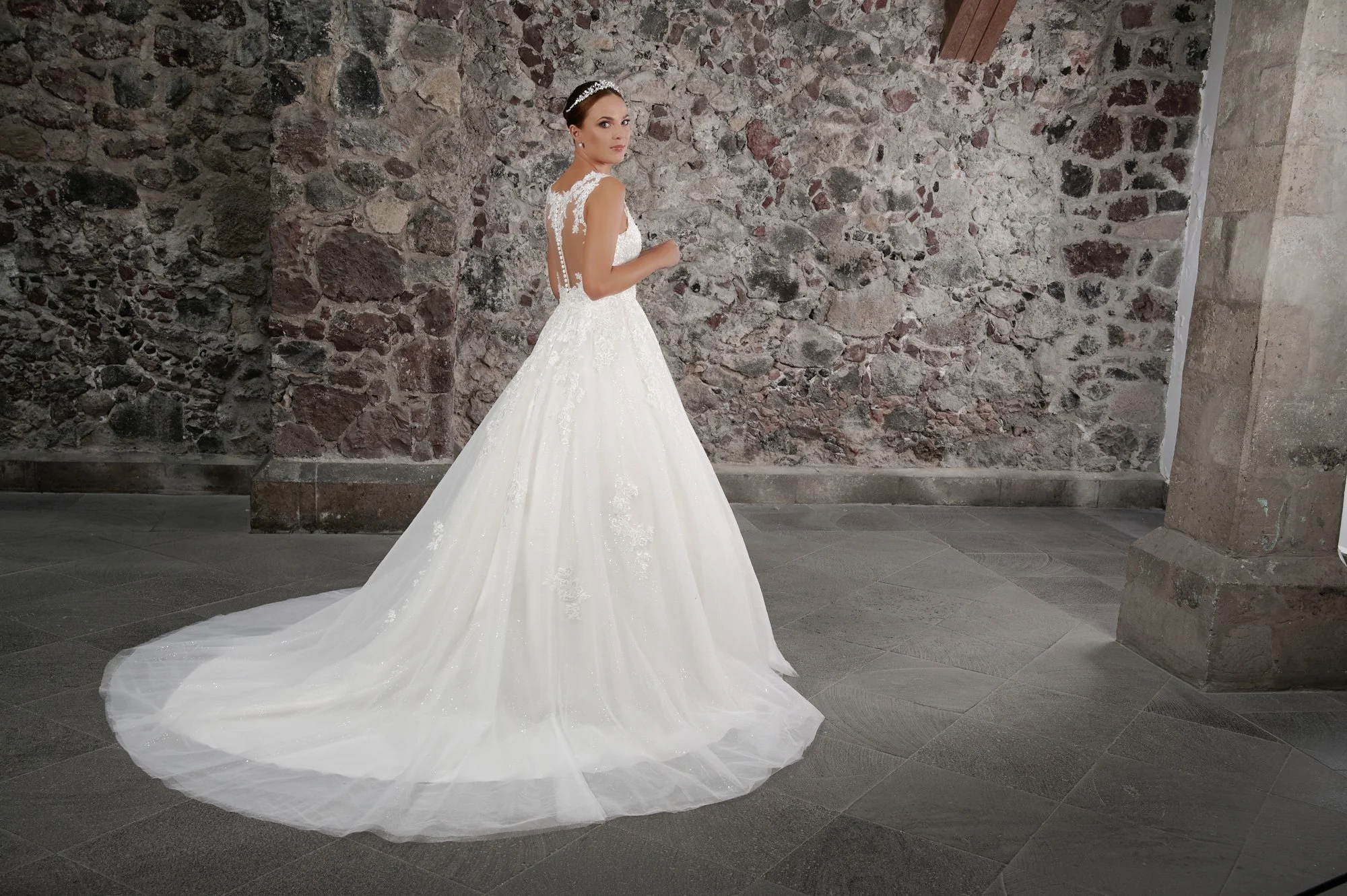 Espalda del vestido de novia Coco con falda princesa de tul brillante y cola larga con encaje.
