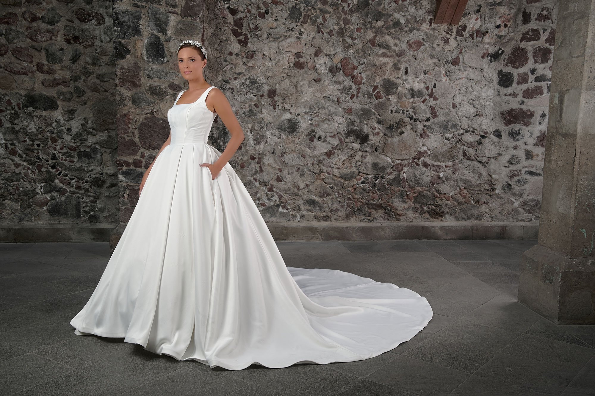 Novia con el vestido Carmen de Bridenformal, princesa de satén liso minimalista, vista frontal con cola.