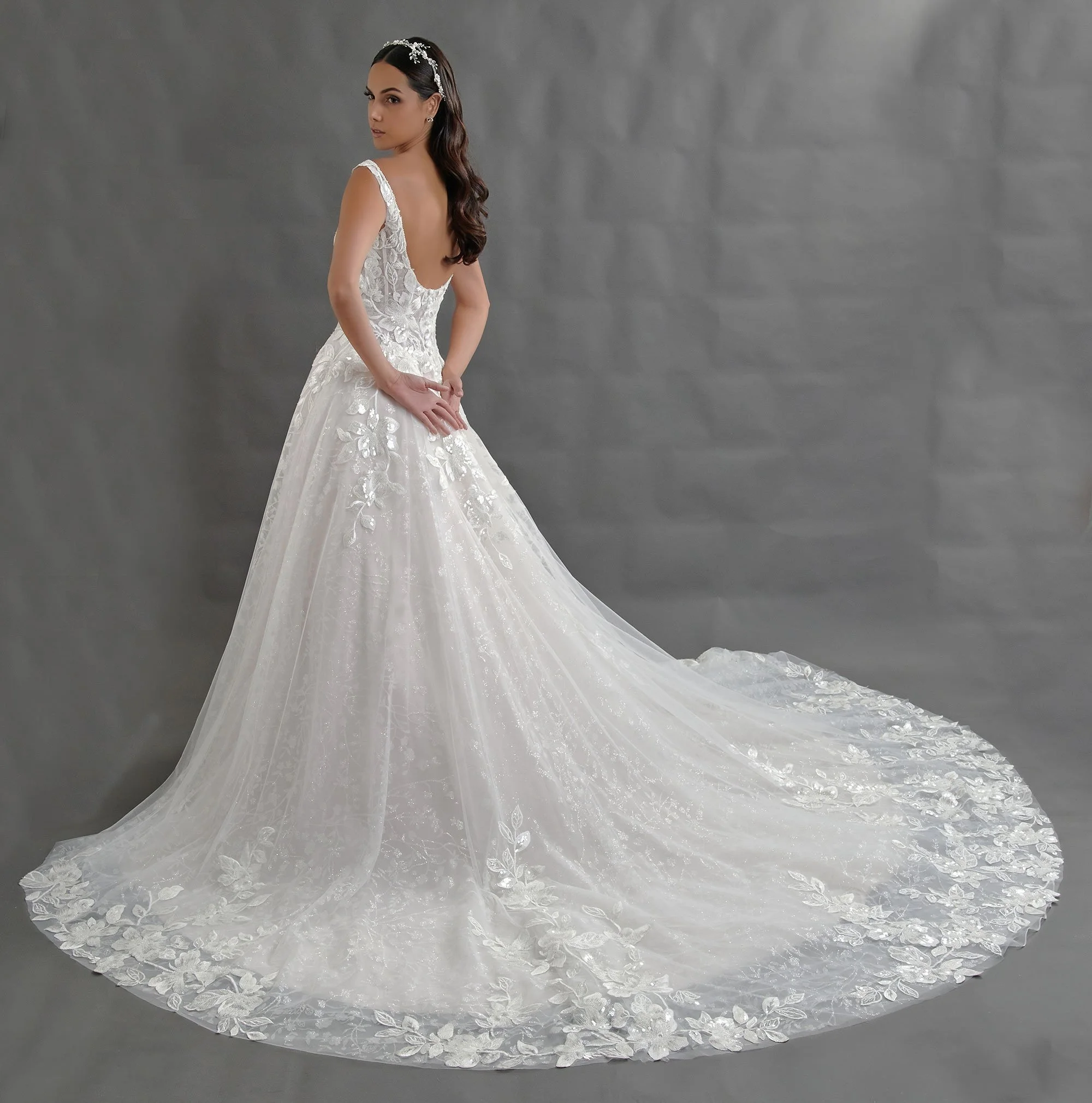 Espalda del vestido de novia Blandina con corsé de amarre y falda de tul con cola larga.