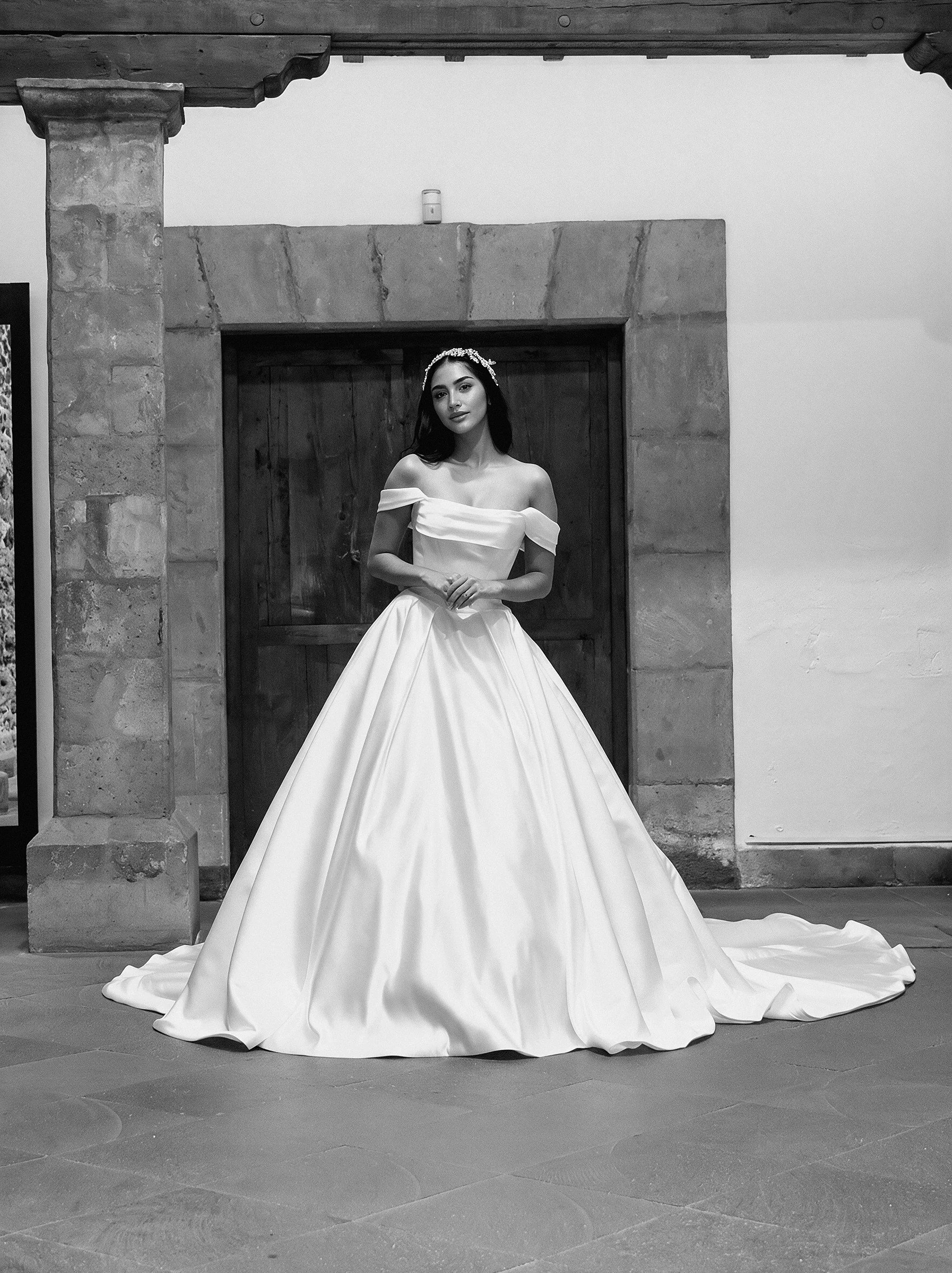 Novia con el vestido Murcia de Bridenformal, princesa de satén con escote bardot, vista frontal completa.