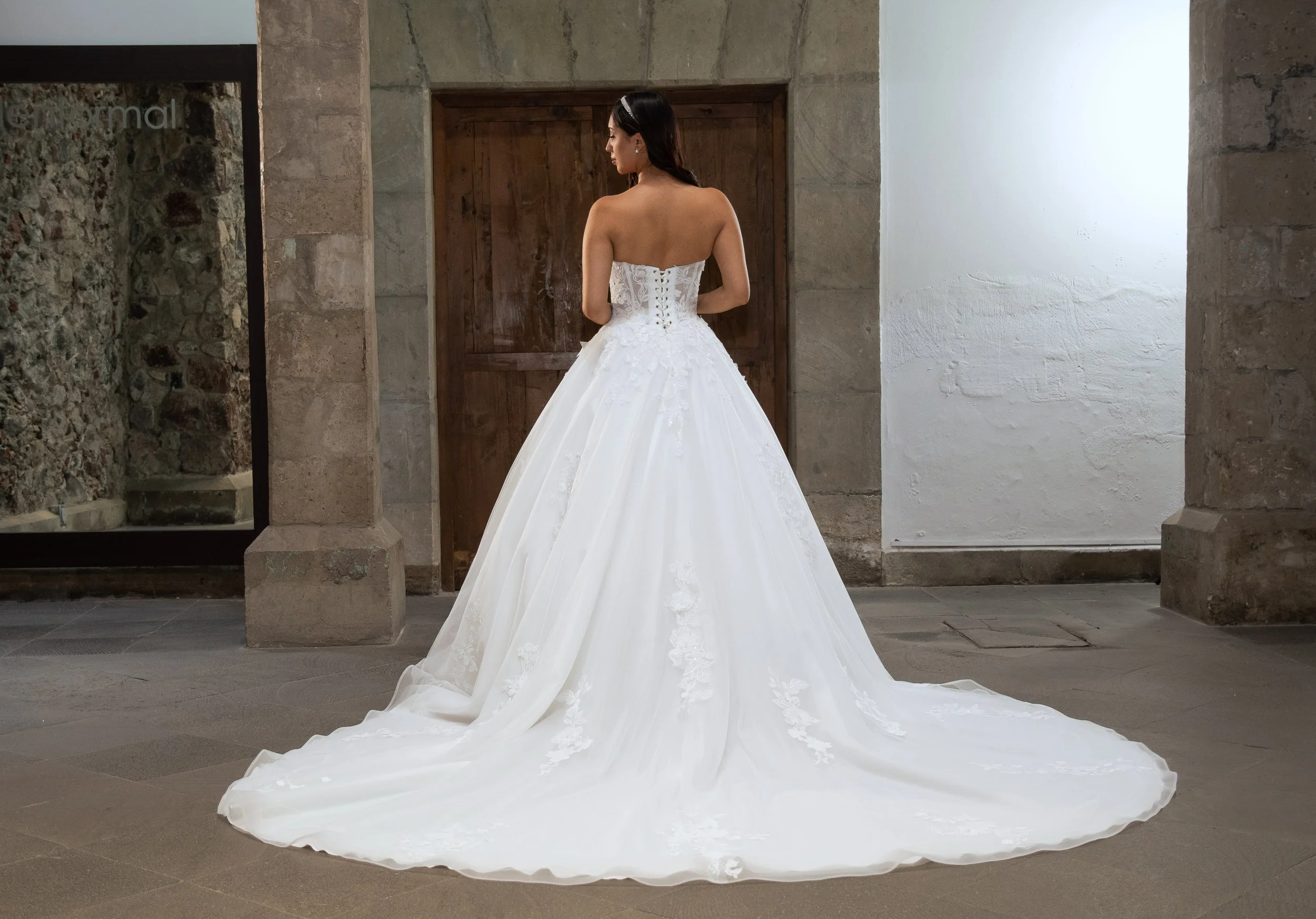 Espalda del vestido de novia Larisa con falda de tul y encaje y cola larga.