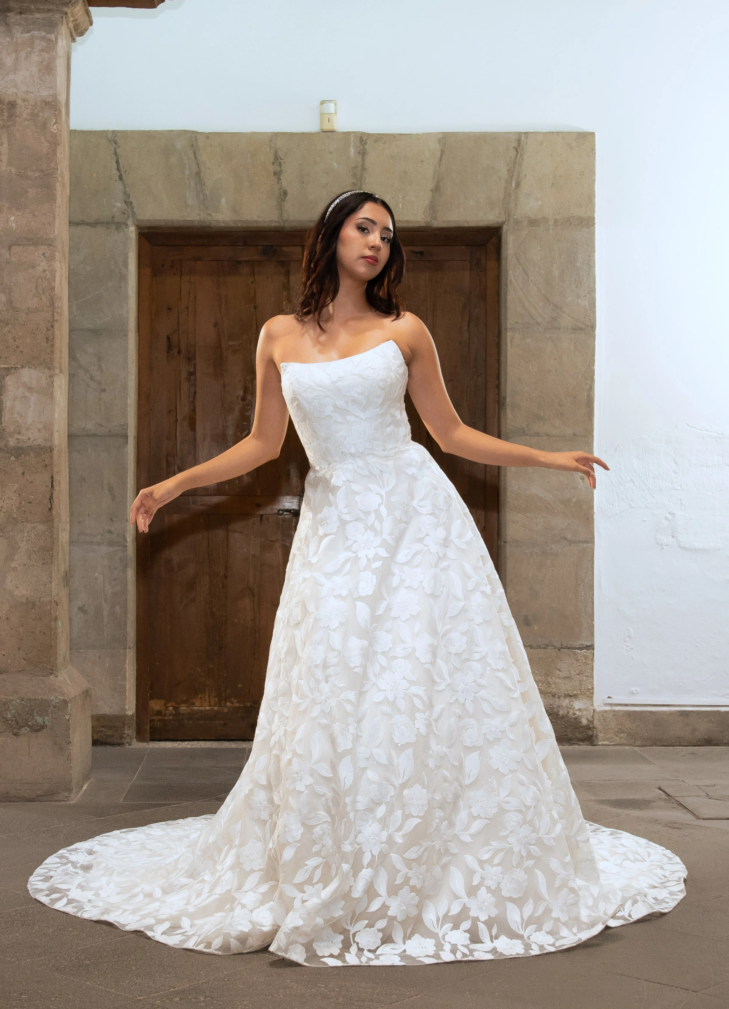 Vestido de novia Look de frente con la falda de aplicaciones florales y la cola extendida en línea A.