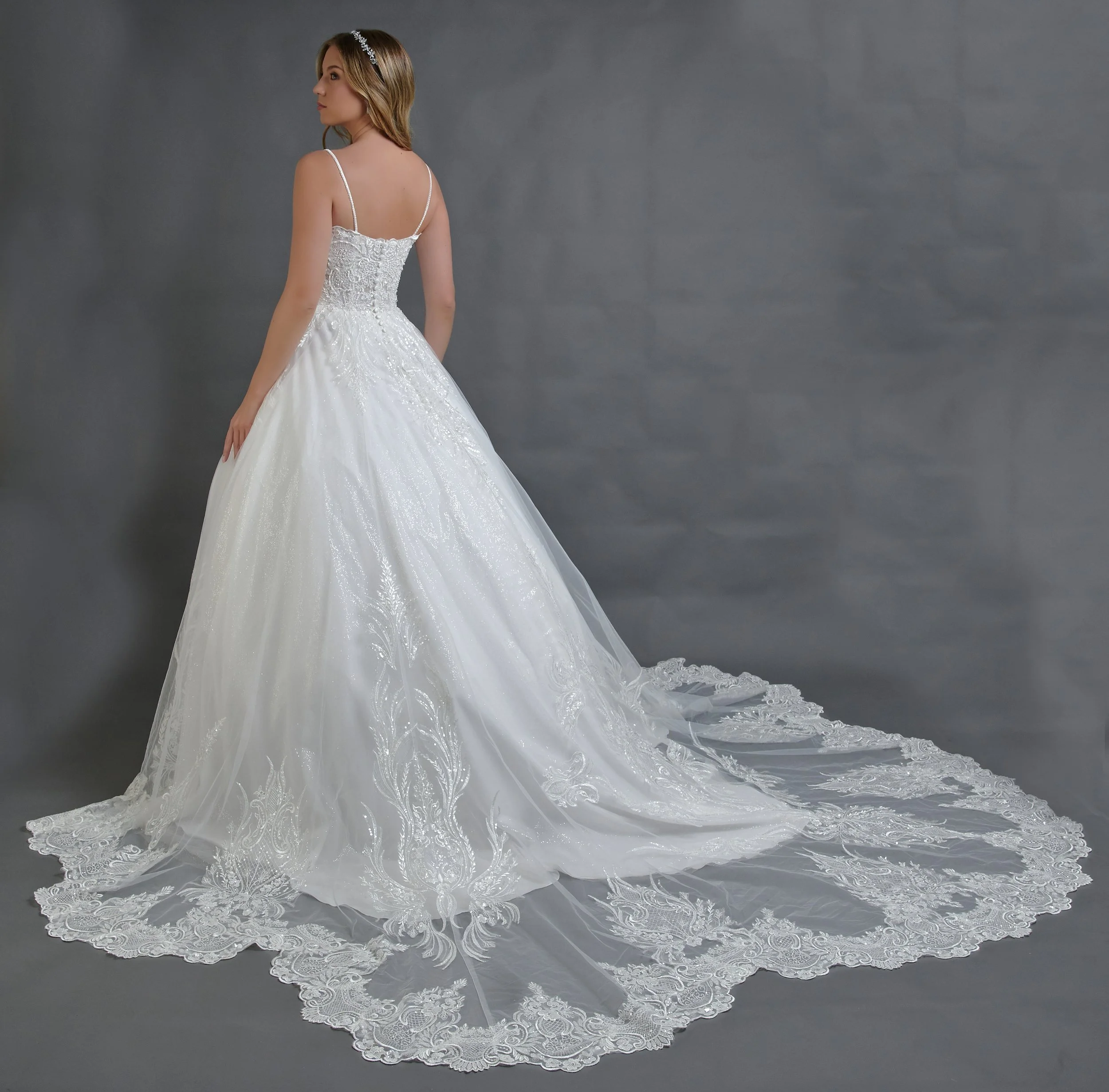 Espalda del vestido de novia Baldemar con falda de tul brillante y cola larga con borde de encaje.