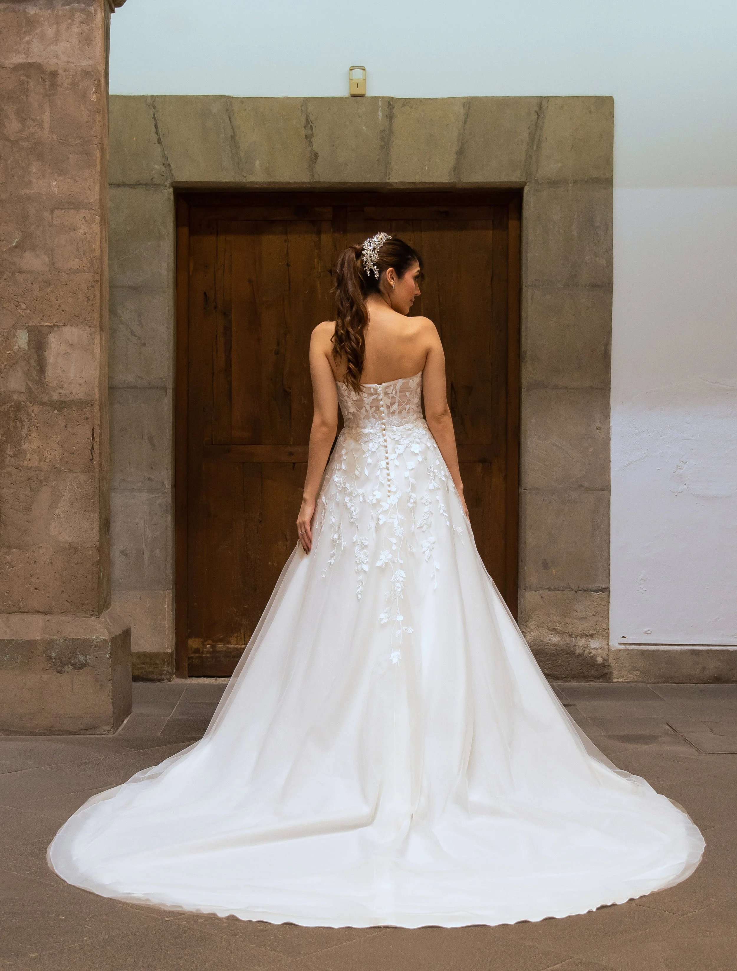 Espalda del vestido de novia Lujo con falda de tul y cola larga.