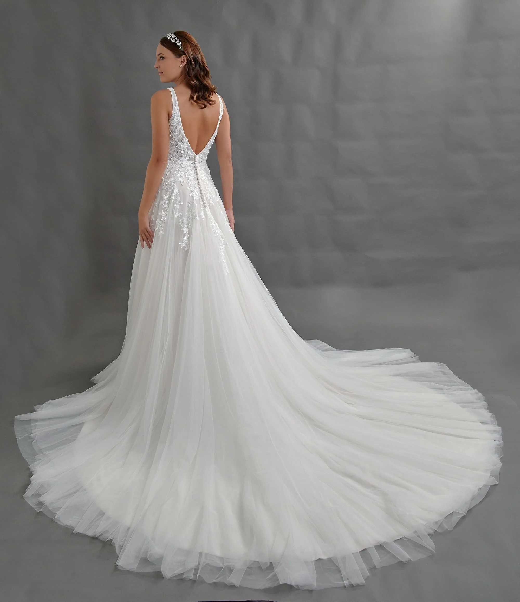 Espalda del vestido de novia Bertha con botones forrados y falda de tul con cola.