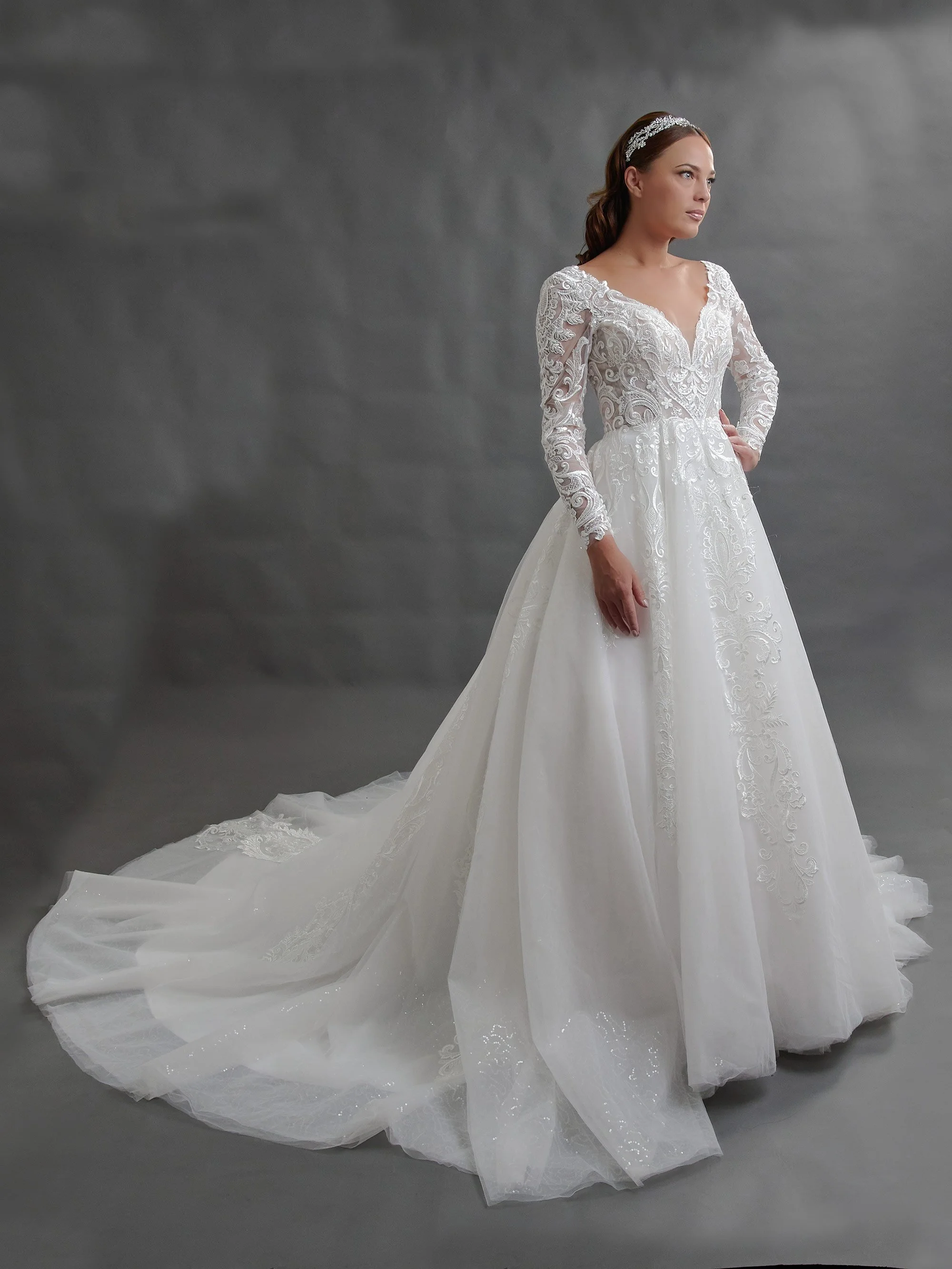 Novia con el vestido Baltasar de Bridenformal, princesa de tul con mangas largas de encaje, vista frontal con cola.
