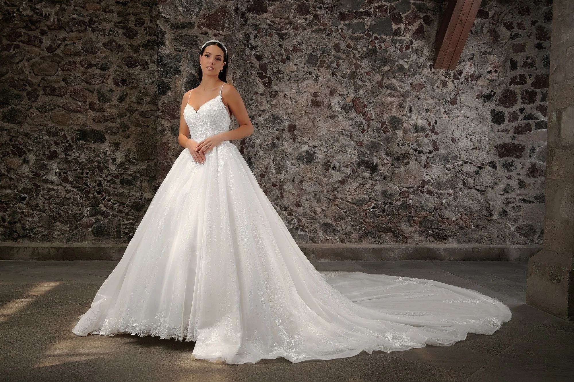 Novia con el vestido Calixto de Bridenformal, princesa de tul con brillo y pedrería, vista frontal con cola.
