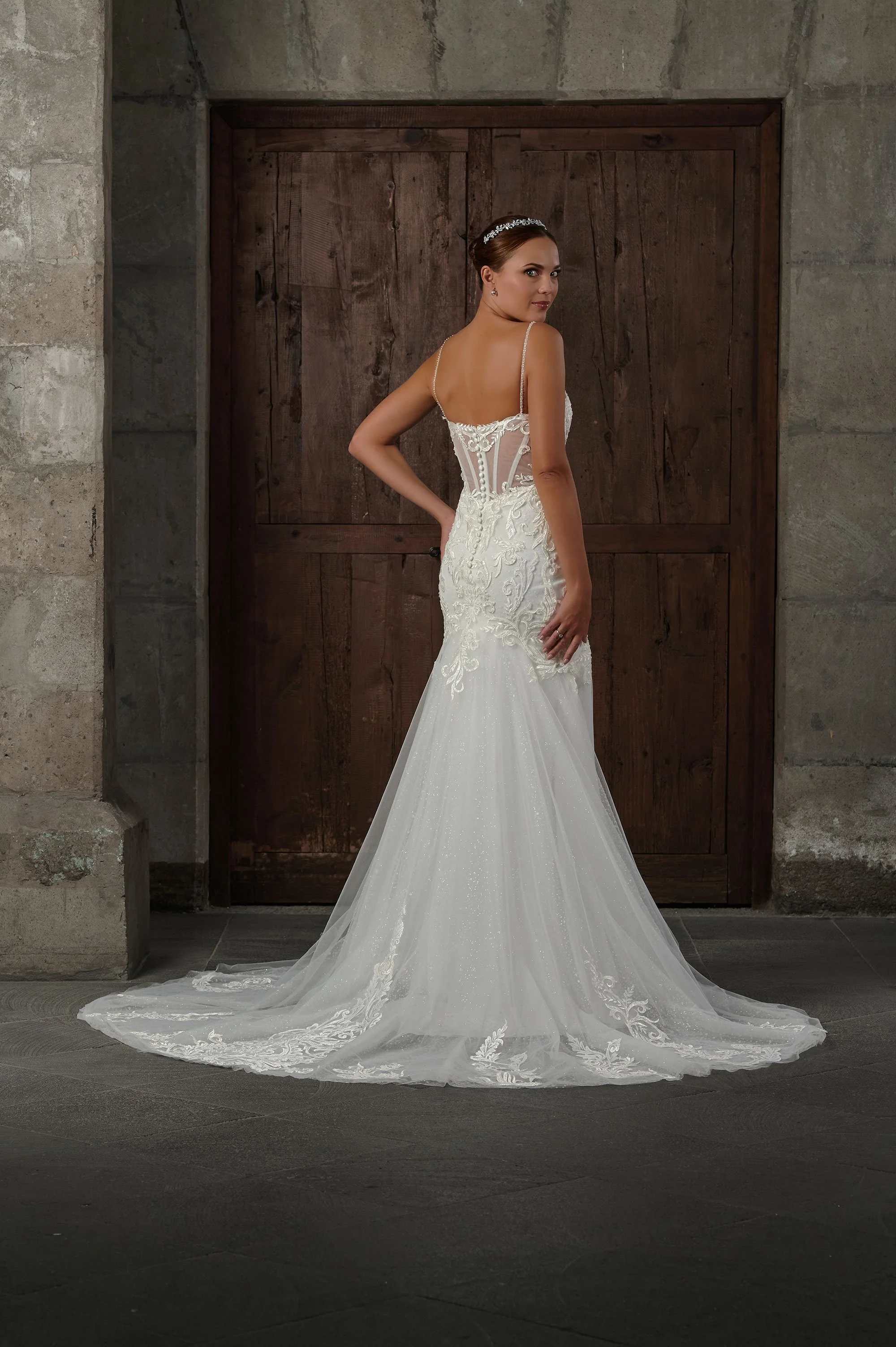 Espalda semitransparente del vestido de novia Qenan con botones forrados y cola larga.