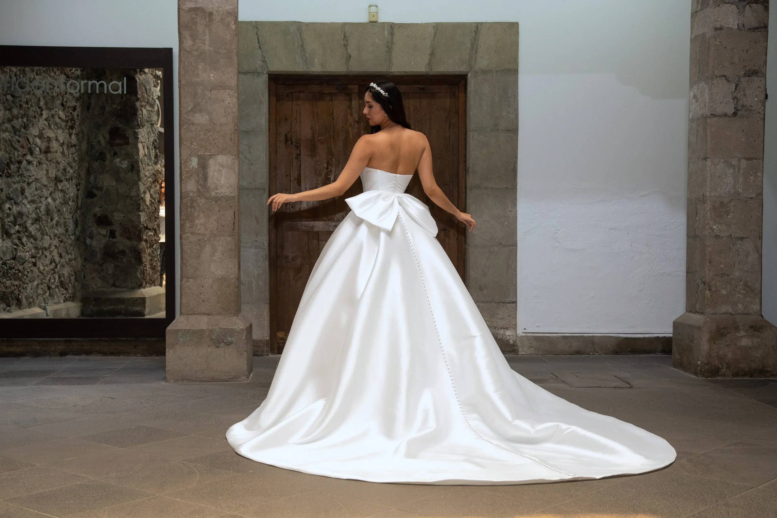 Espalda del vestido de novia Lauren con moño de satén y cola larga.