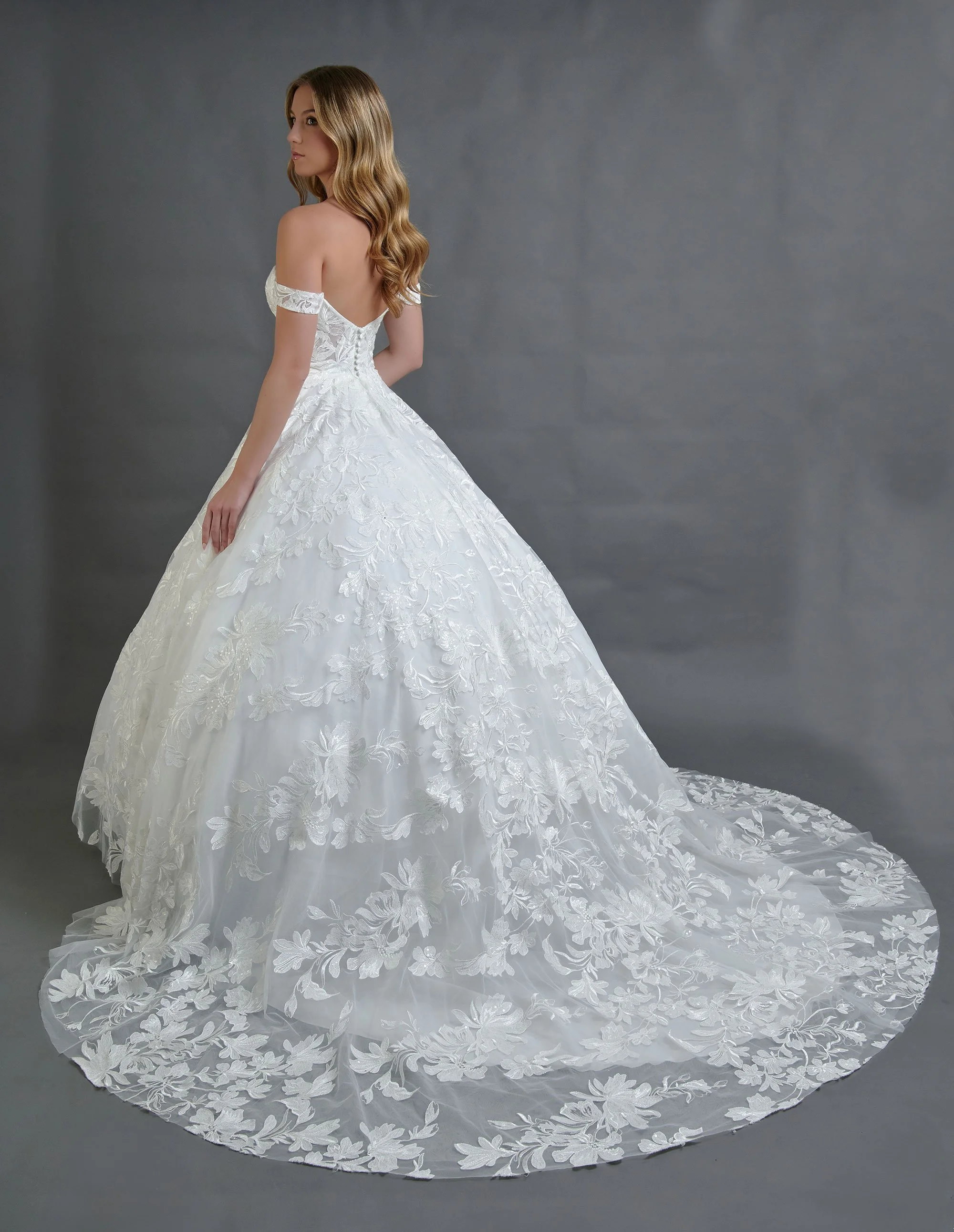 Espalda del vestido de novia Barcelona con falda bordada en encaje floral y cola larga.