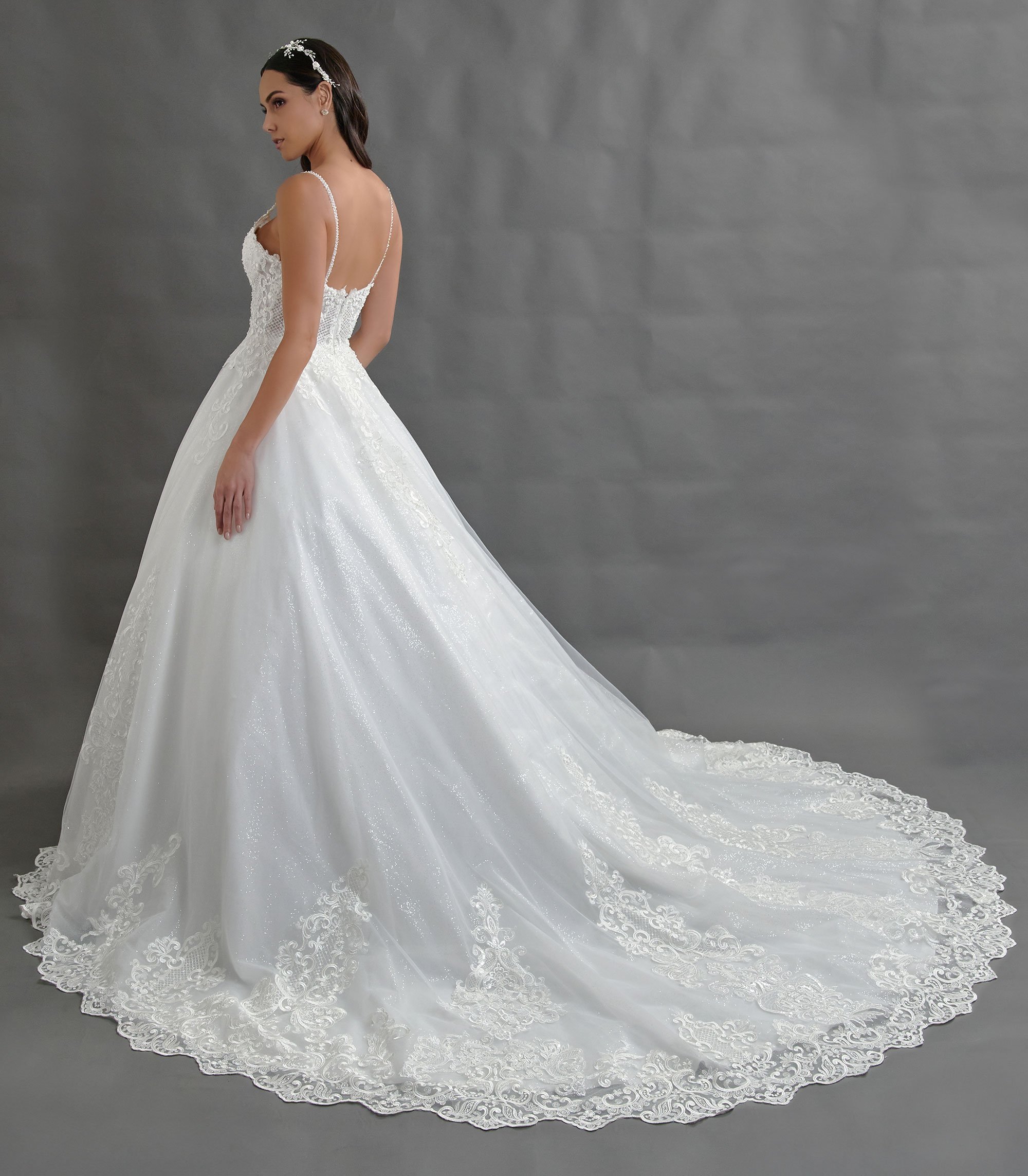 Espalda del vestido de novia Bernabeu con escote profundo en V y falda de tul con cola larga.