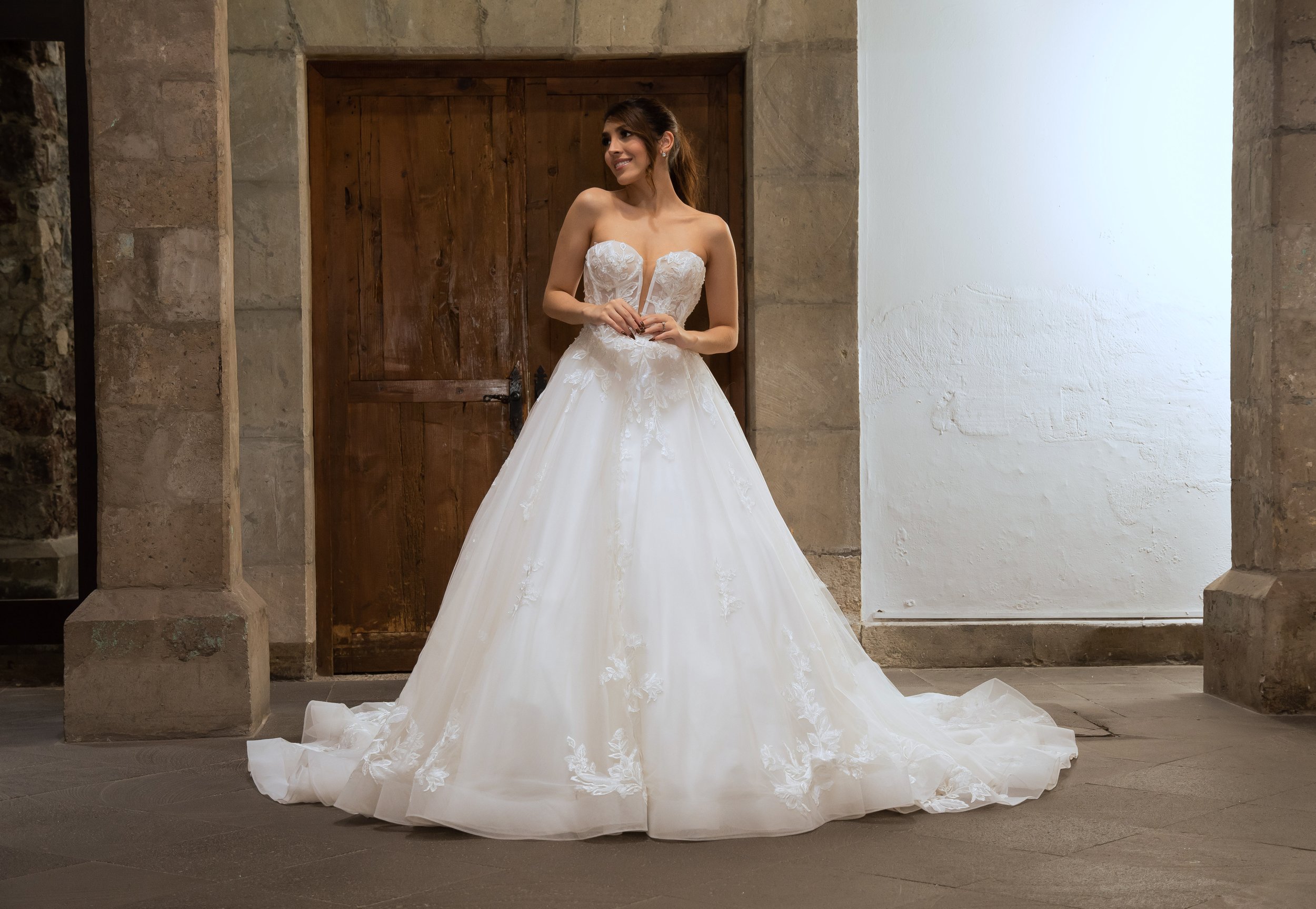 Novia con el vestido Lina de Bridenformal, línea A de encaje con escote corazón profundo, vista frontal completa.