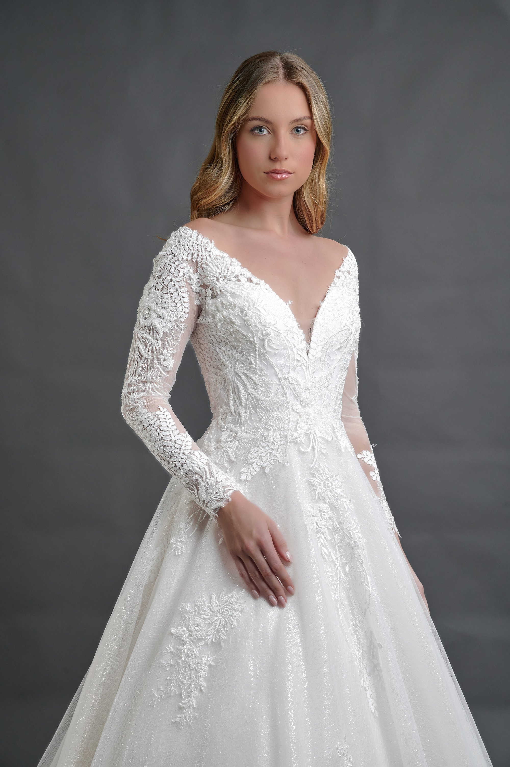 Detalle del escote en V y las mangas largas de encaje del vestido de novia Basilea.