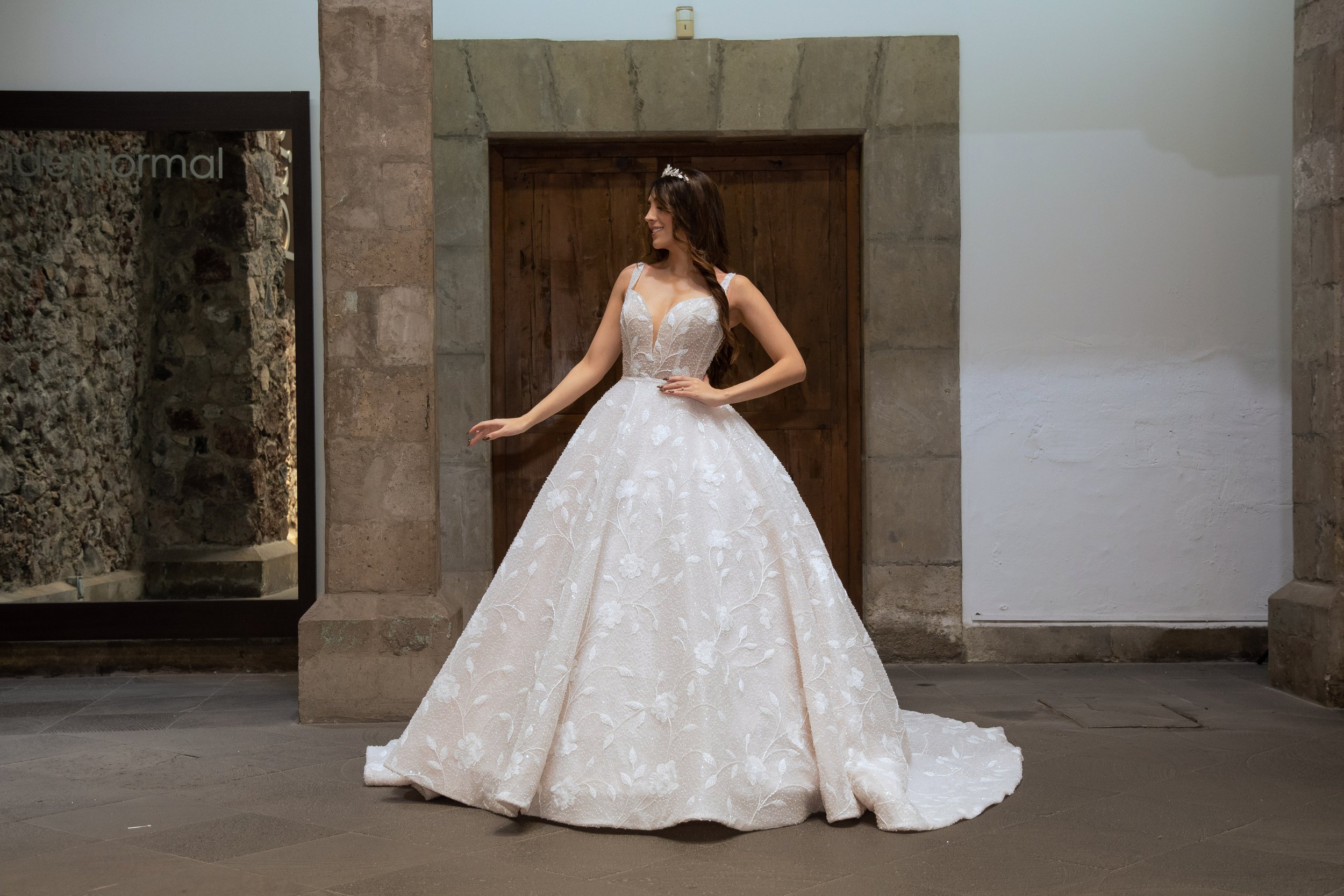 Novia con el vestido Trescia de Bridenformal, silueta princesa con brillo y escote en V, vista frontal completa.