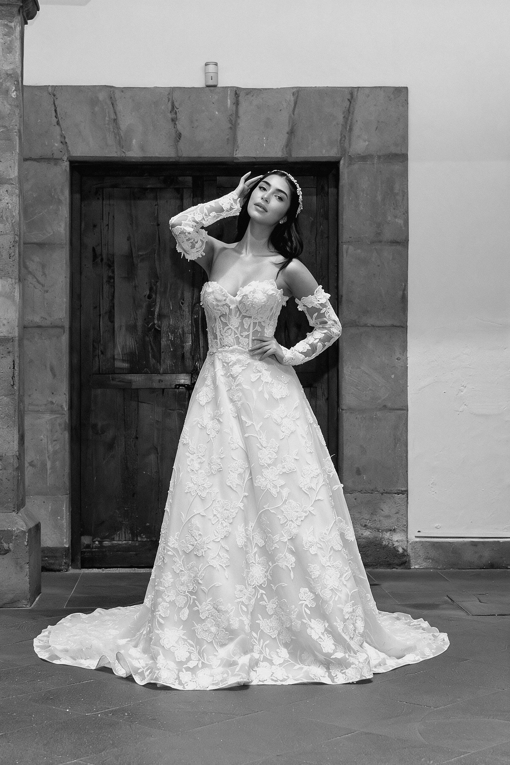 Vestido de novia Lucas de frente luciendo las mangas largas de encaje desmontables.