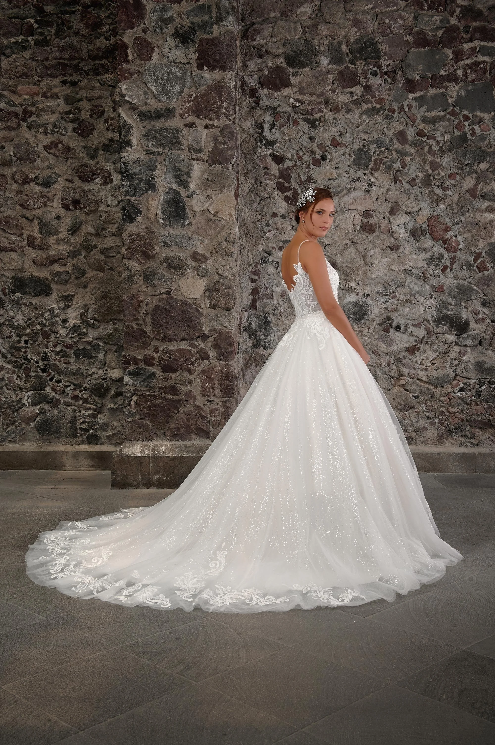 Espalda del vestido de novia Colmena con falda princesa de tul brillante y cola larga con encaje barroco.