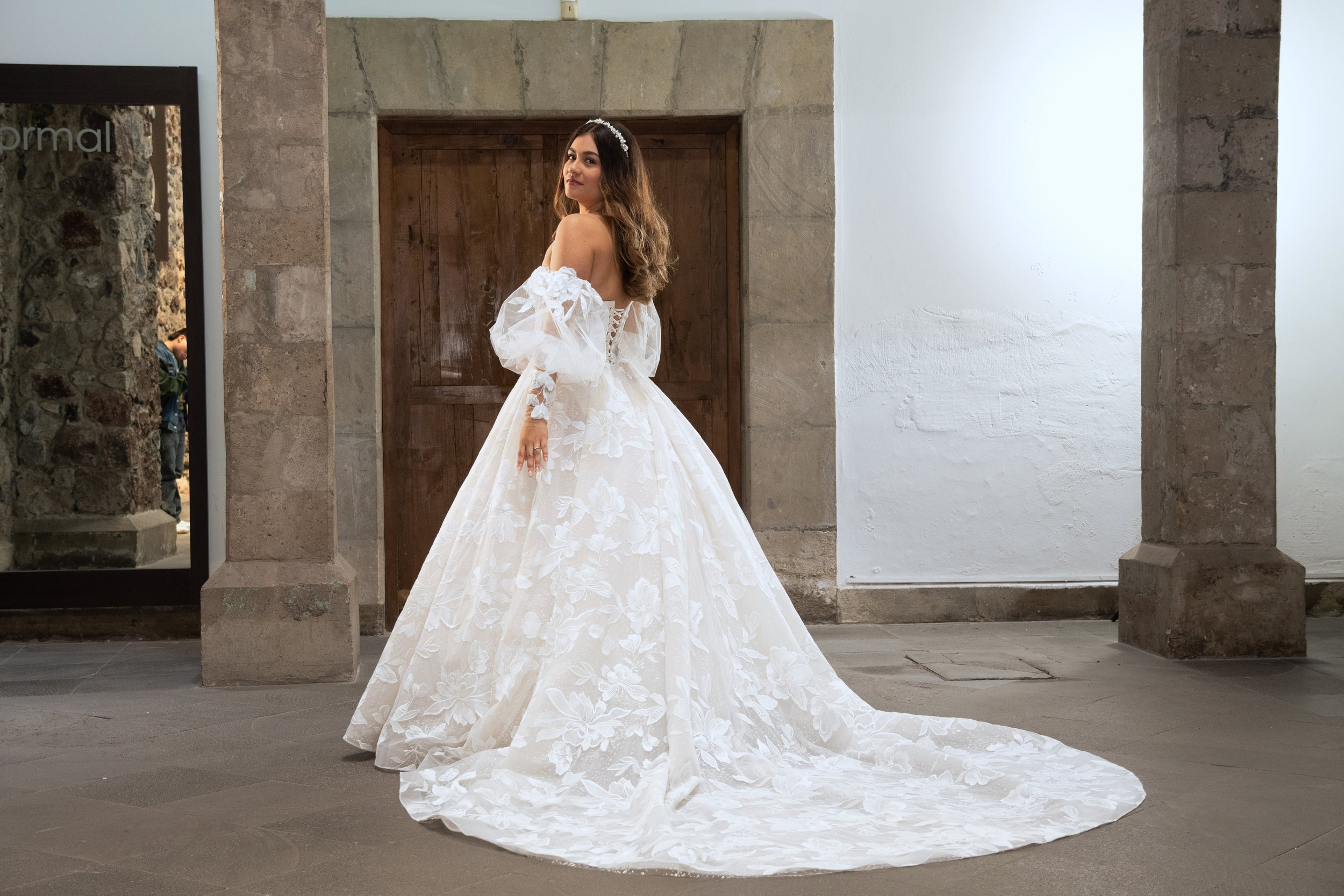 Espalda del vestido de novia Lupita con cola larga cubierta de aplicaciones florales.