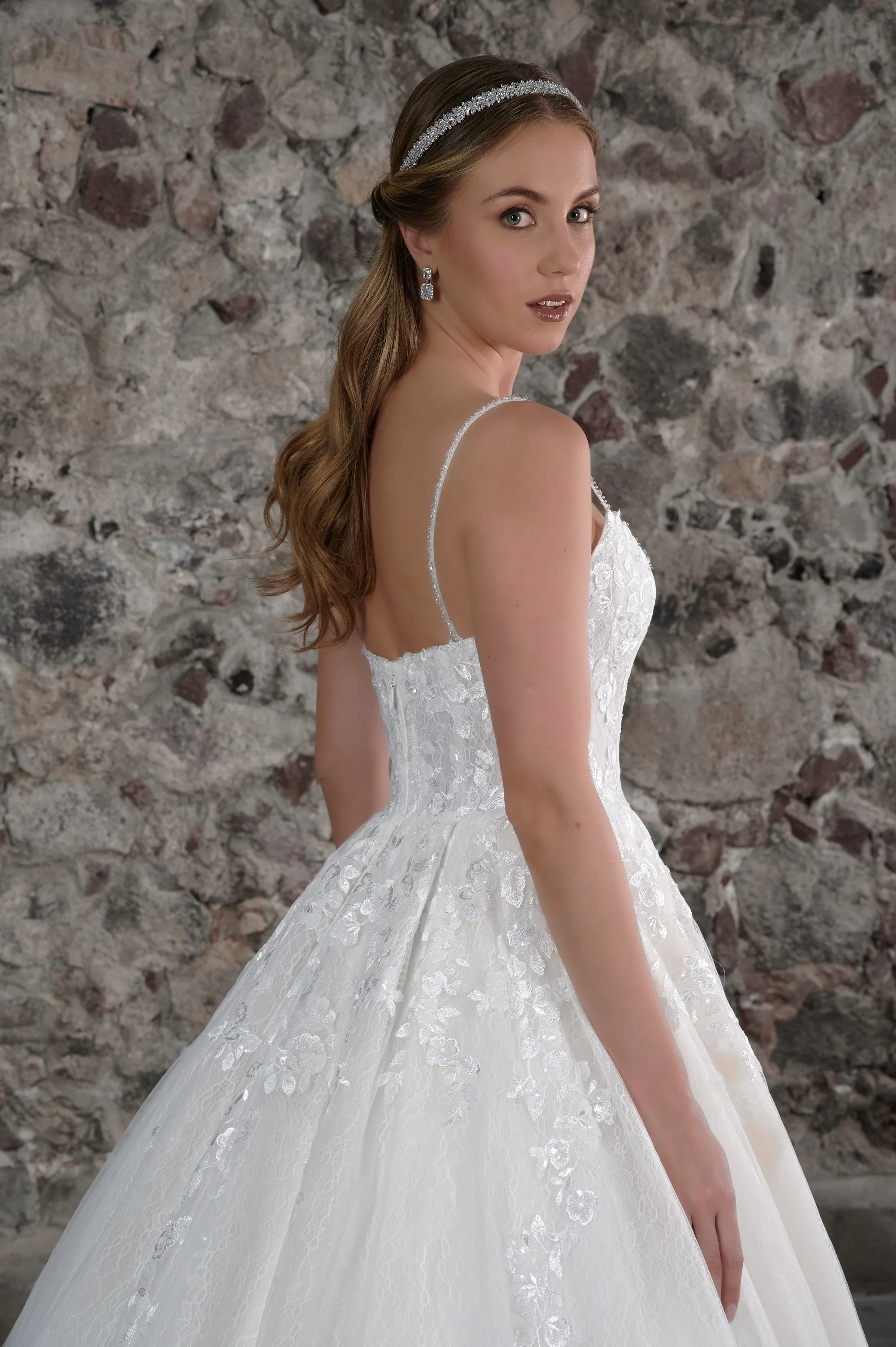 Novia con el vestido Carla de Bridenformal, princesa de tul con brillo y encaje floral, vista frontal con cola.