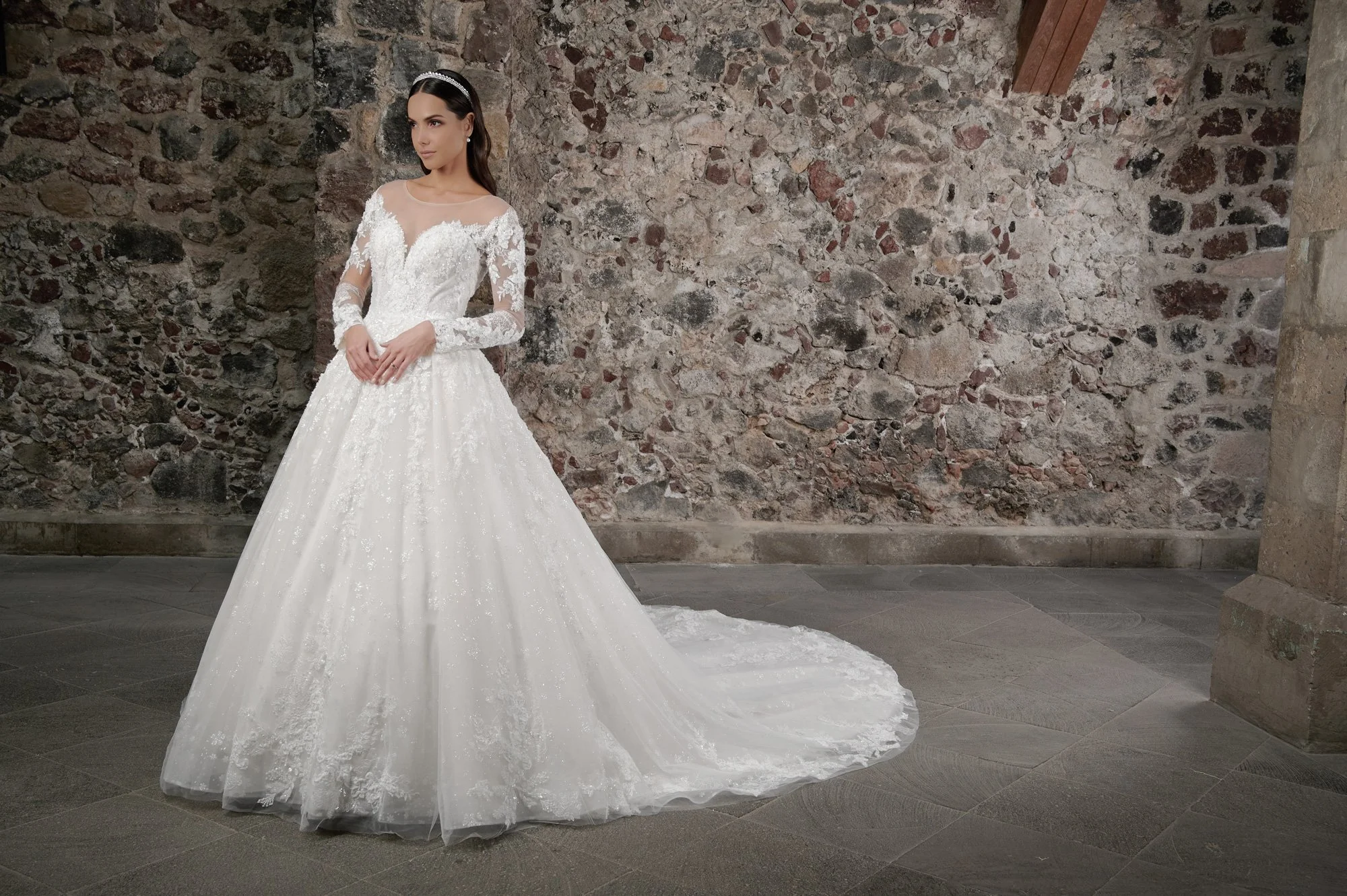 Novia con el vestido Cedilla de Bridenformal, princesa de manga larga con encaje floral bordado, vista frontal con cola.