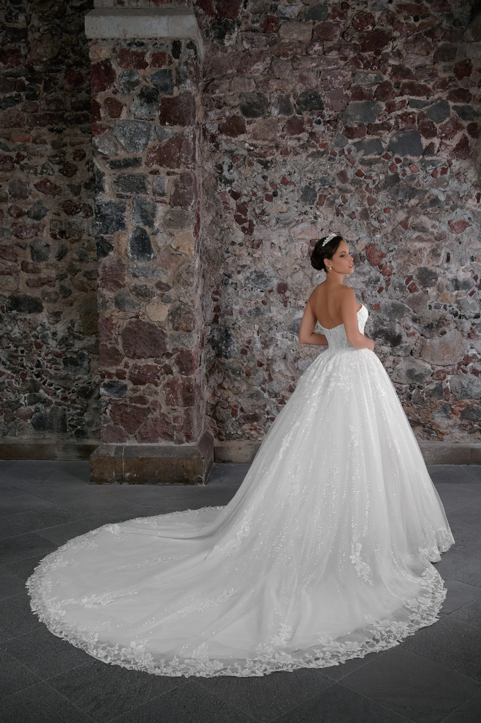 Espalda del vestido de novia Carlota con falda princesa de tul brillante y cola larga con encaje.