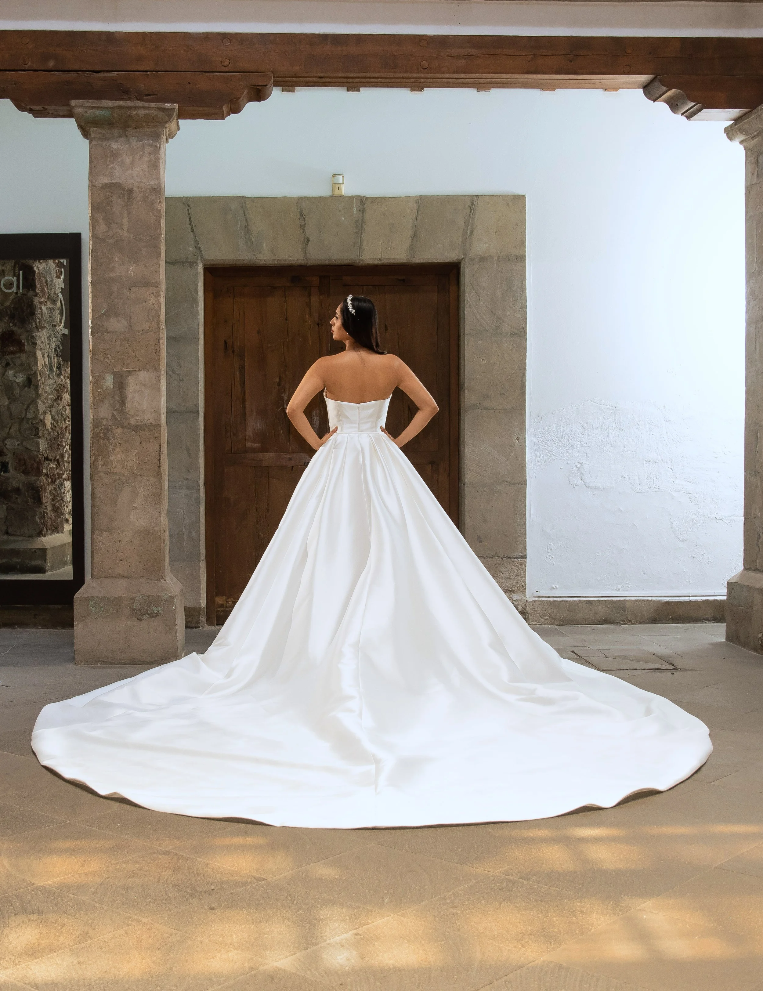 Espalda del vestido de novia Love en satén con la sobrefalda y cola extendida.