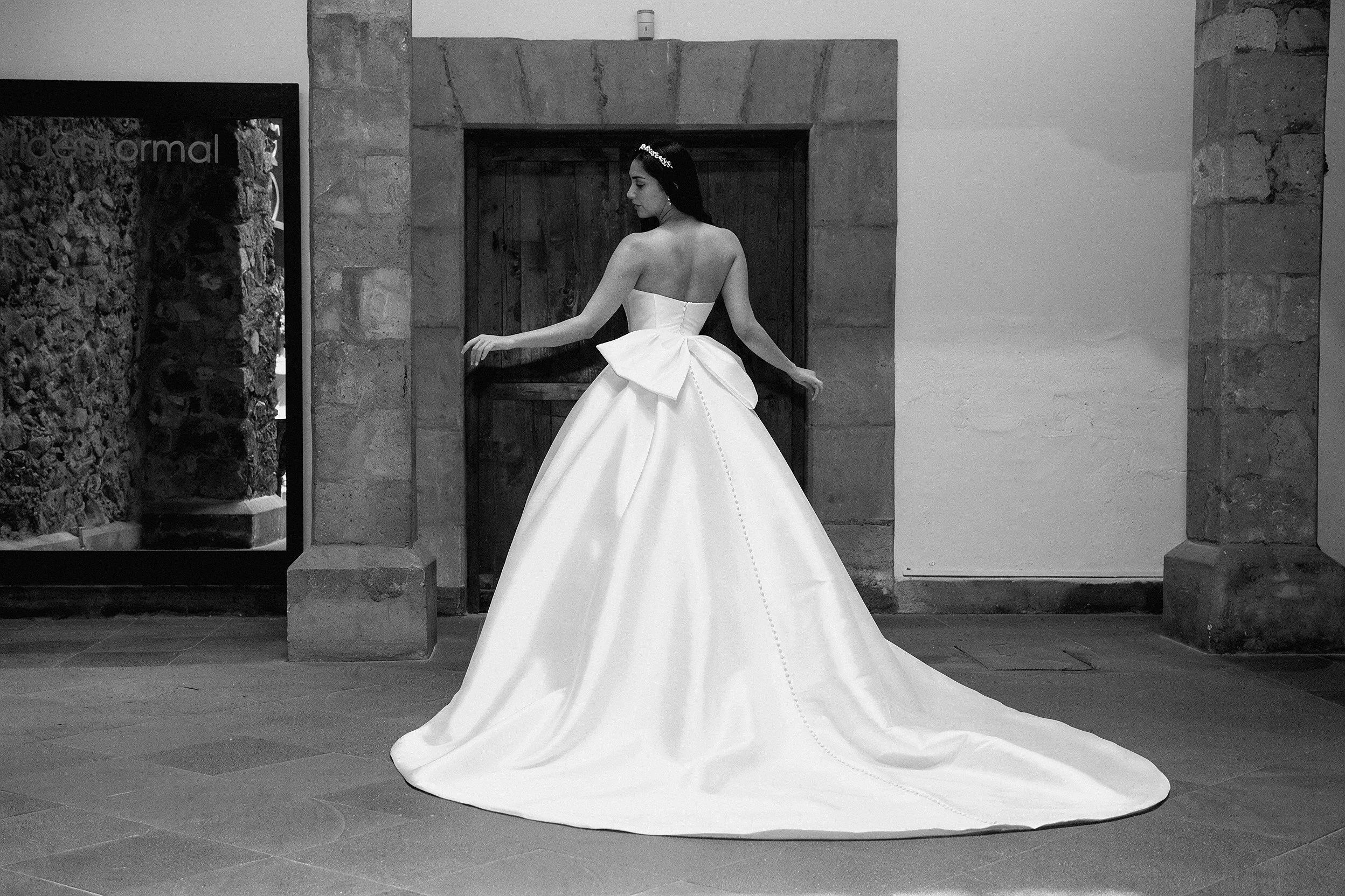 Espalda del vestido de novia Lauren con moño de satén y cola larga.