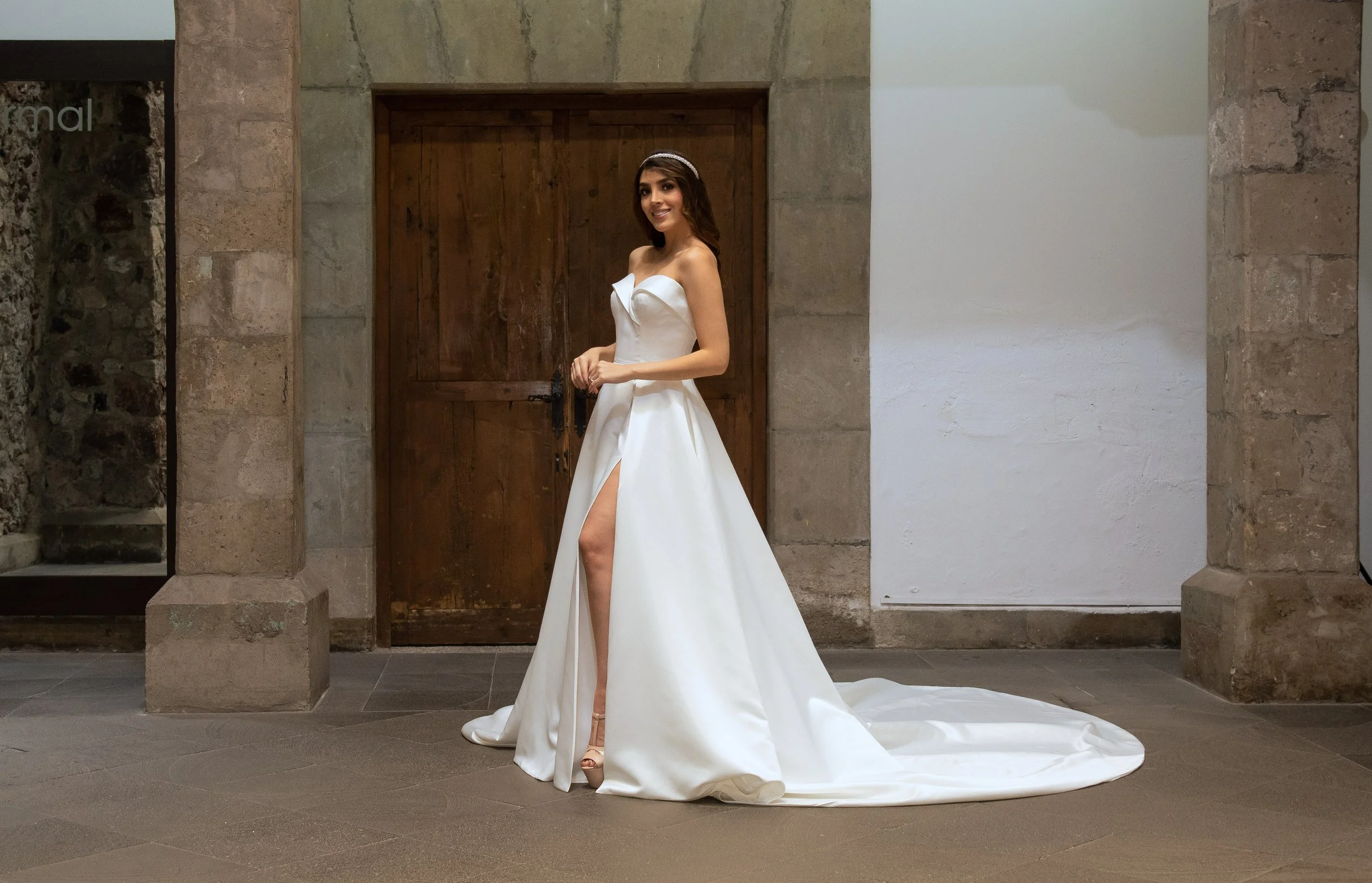 Vestido de novia Warwick de perfil mostrando la abertura frontal de la falda de satén.