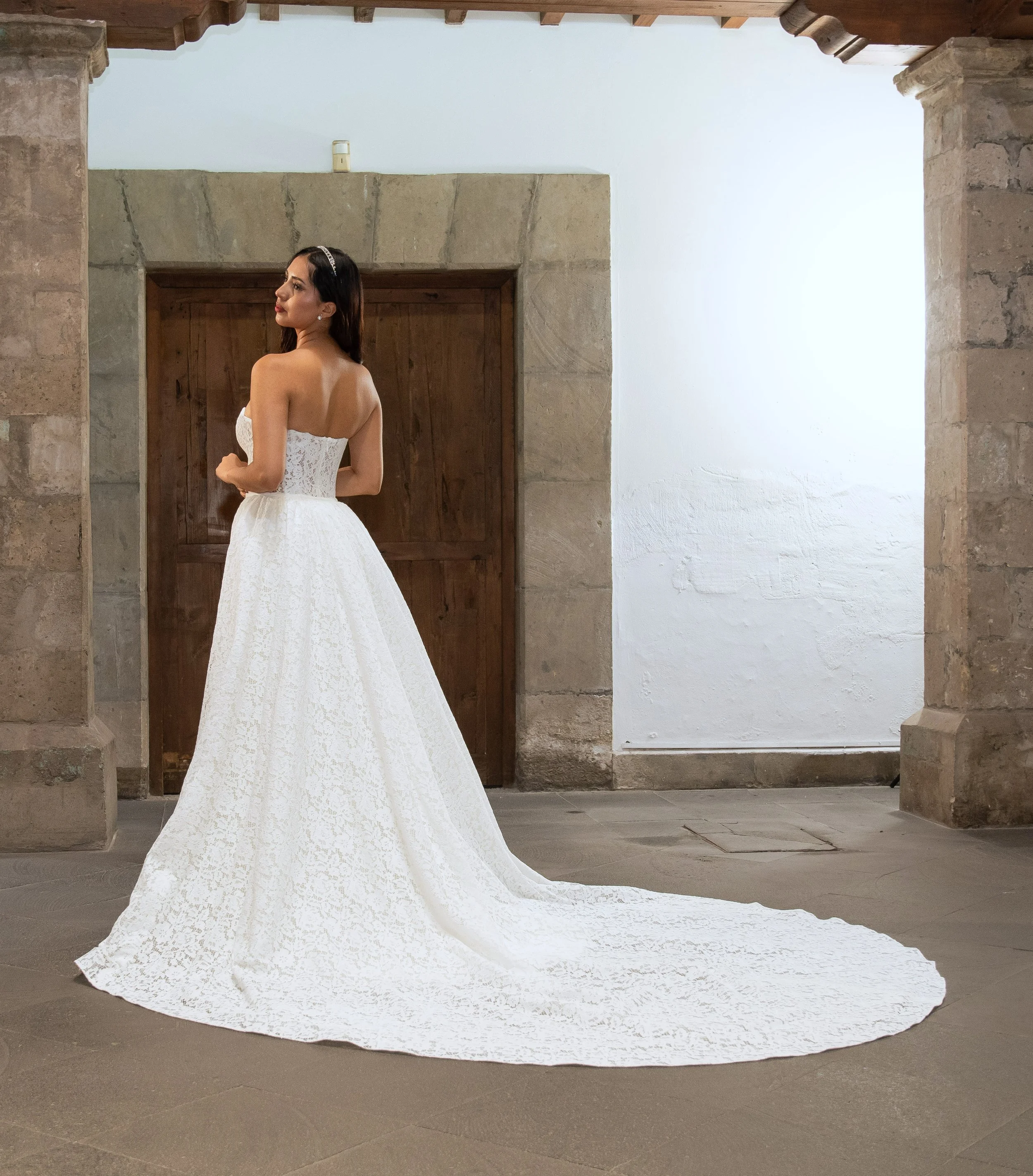 Vista de tres cuartos de la espalda del vestido de novia Leah, con corsé de encaje floral y espalda descubierta.