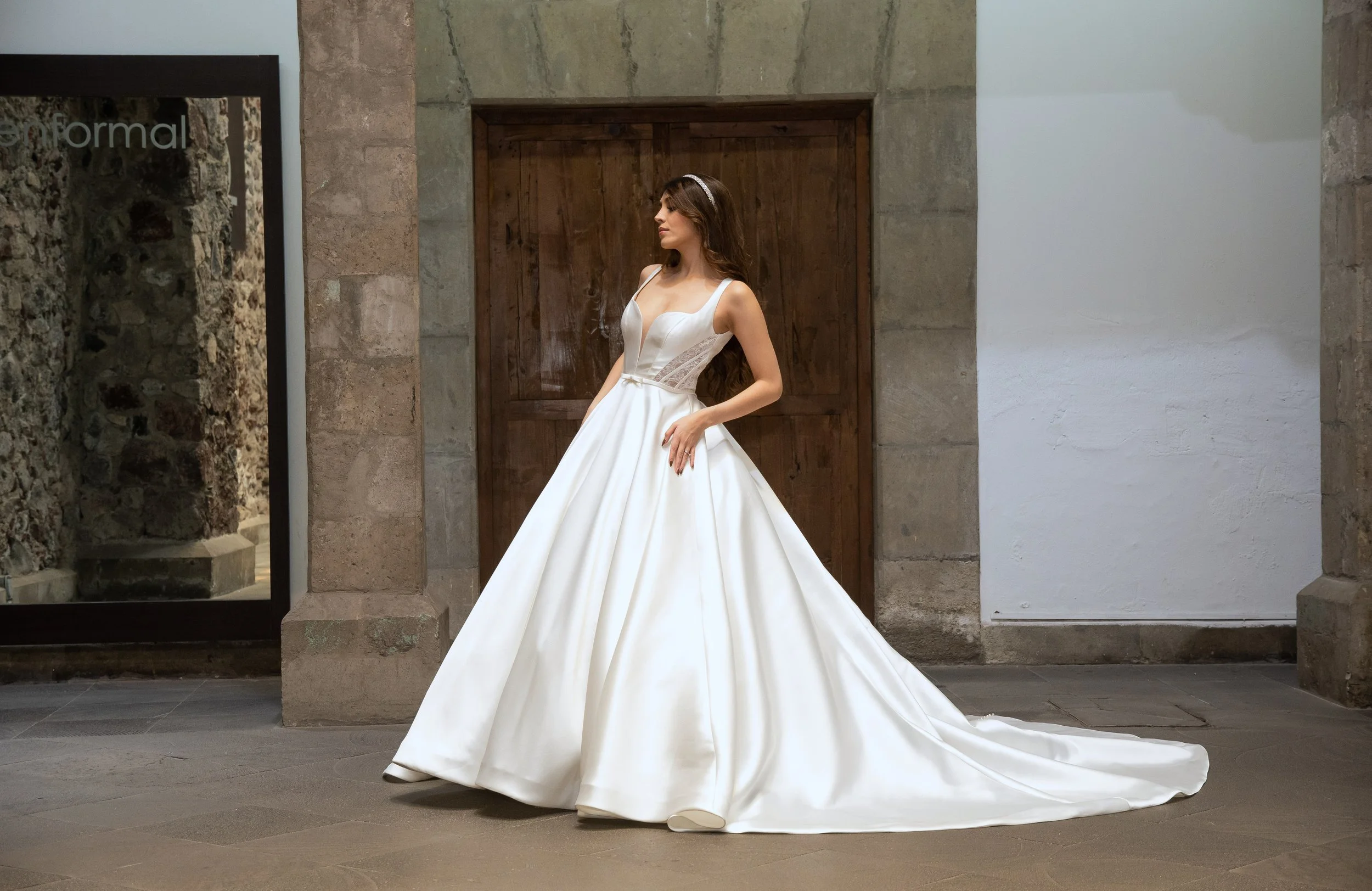 Novia con el vestido Wellrose de Bridenformal, línea A de satén con escote recto y tirantes anchos, vista frontal completa.