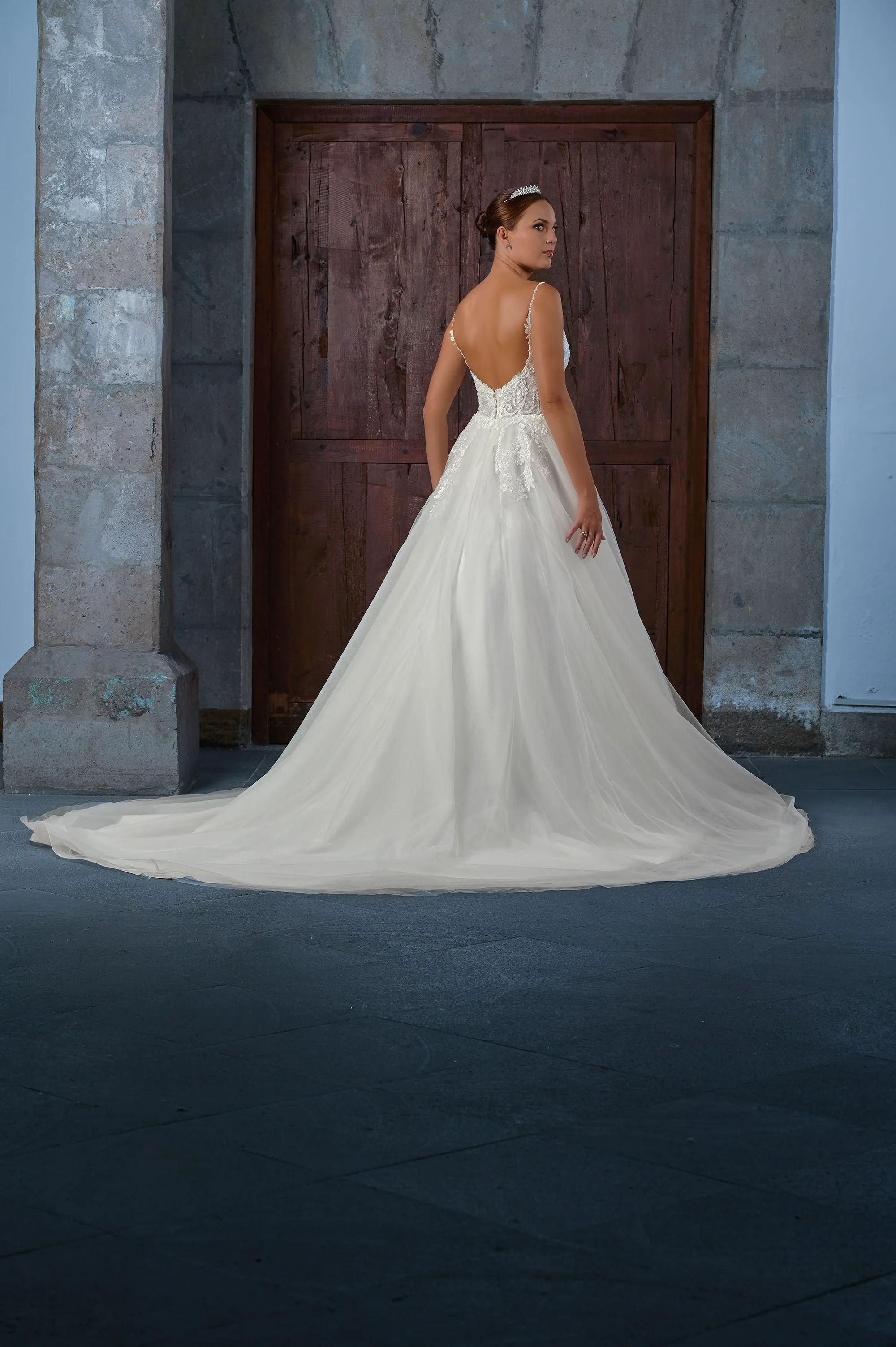 Espalda descubierta del vestido de novia Qenel con falda de tul y cola larga.