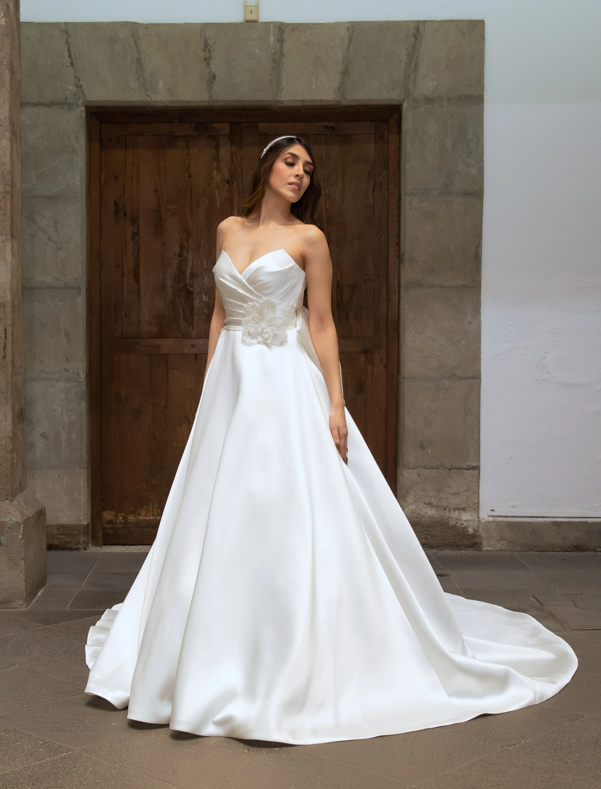 Novia con el vestido Loretta de Bridenformal, línea A de satén con escote corazón drapeado, vista frontal completa.