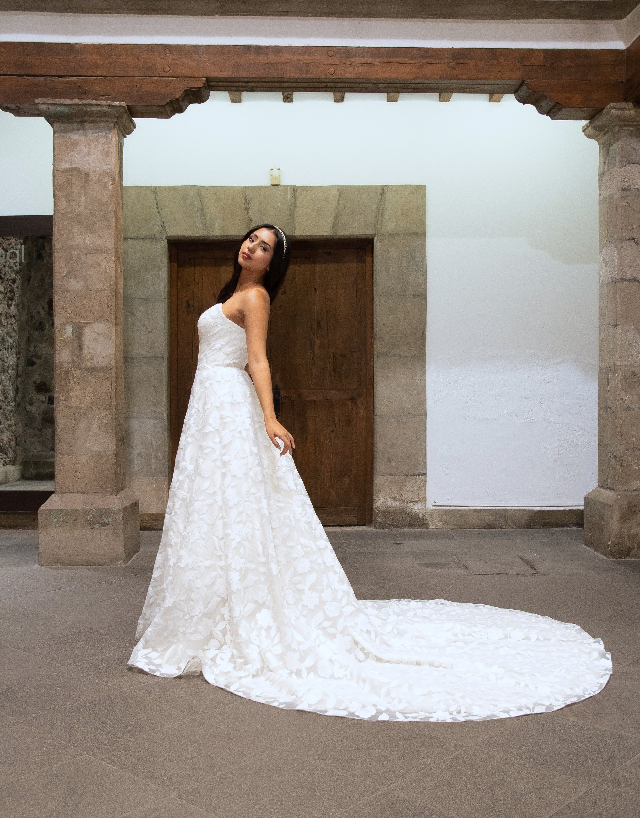 Vestido de novia Look de perfil con la cola de aplicaciones florales extendida en línea A.