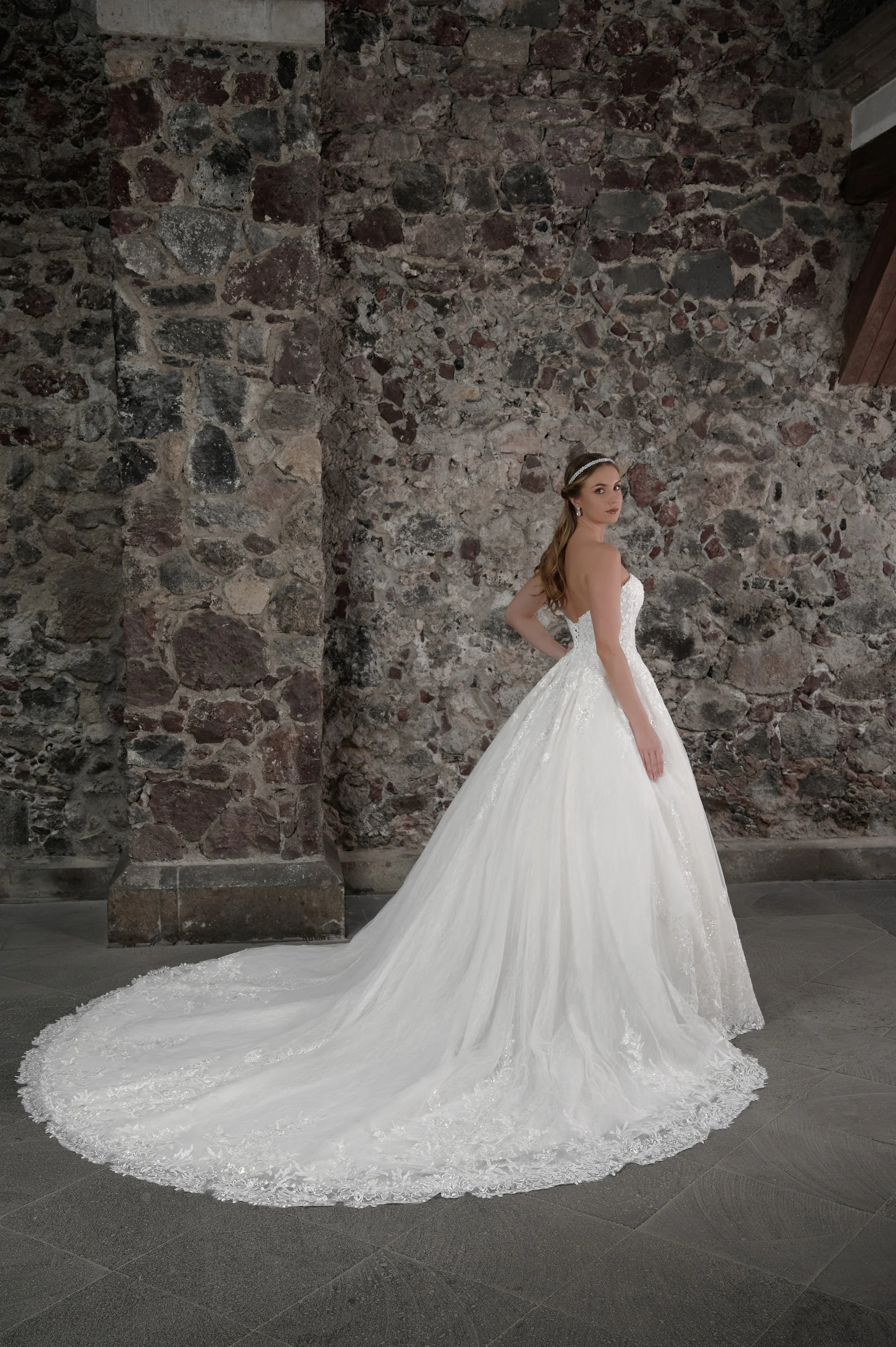 Espalda del vestido de novia Carmela con falda princesa de tul y cola larga con encaje.