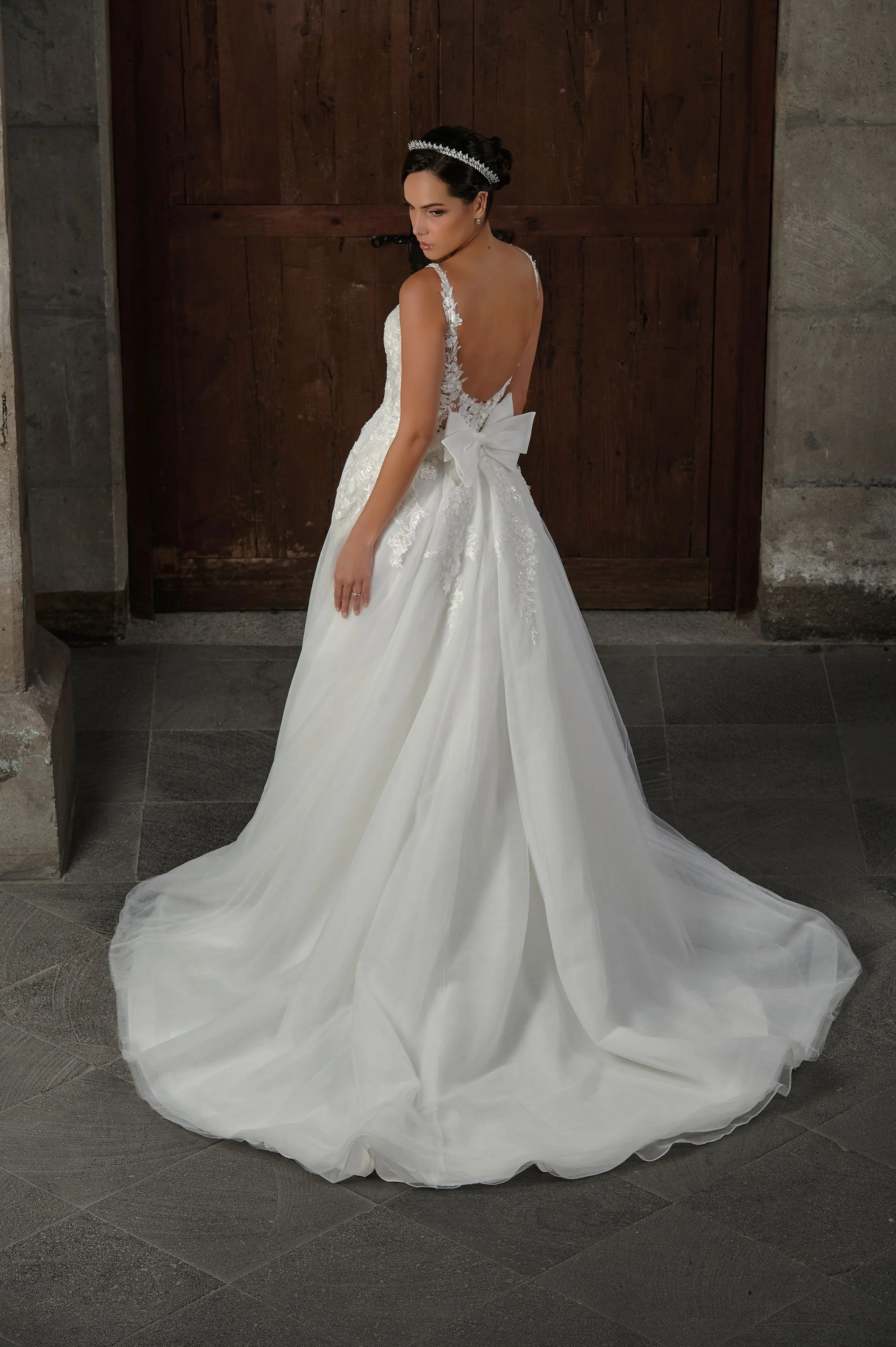 Espalda baja del vestido de novia Qerat con lazo de tul y cola larga.
