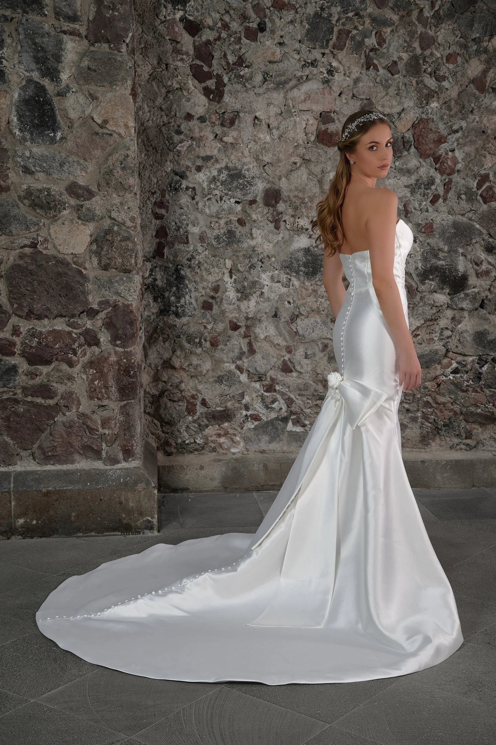 Espalda del vestido de novia Cima con botones forrados y lazo de flores en la cola.