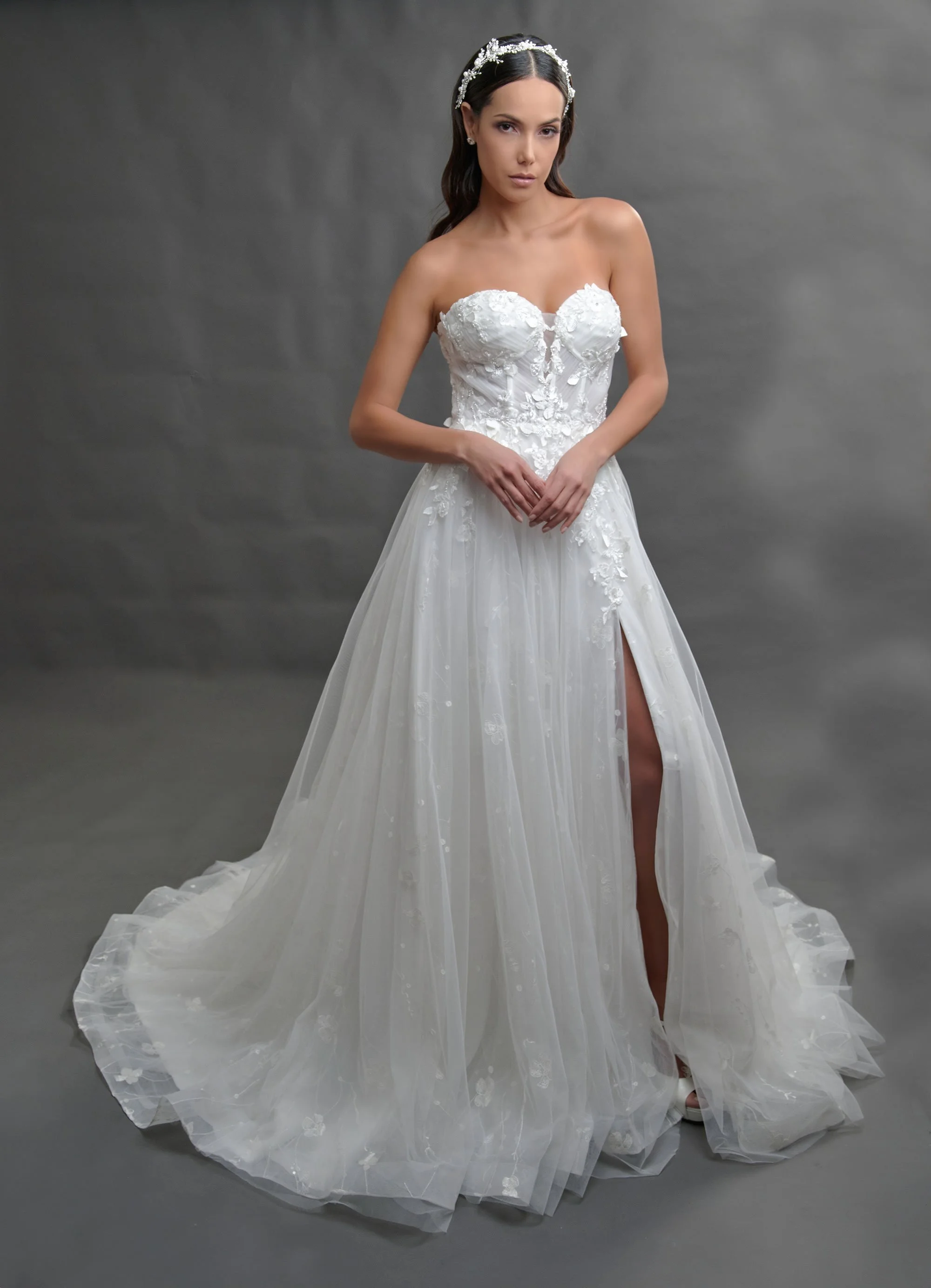 Novia con el vestido Brandon de Bridenformal, línea A de tul con encaje y abertura frontal, vista frontal con cola.