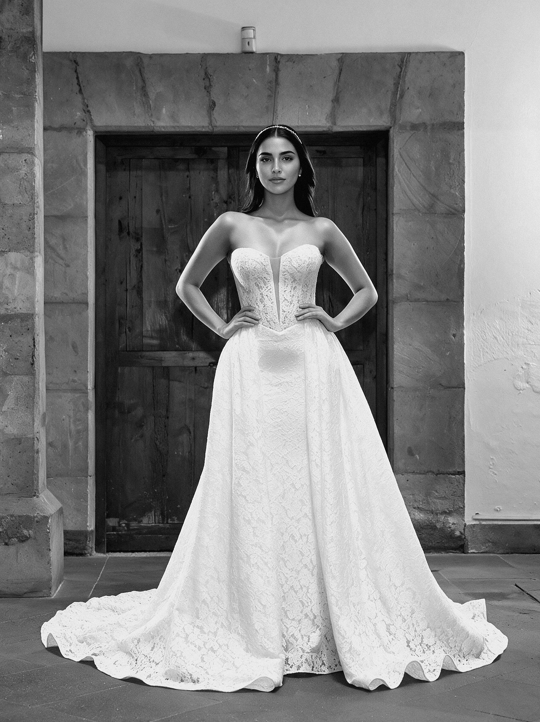 Vestido de novia Lea con la sobrefalda de encaje desmontable puesta, que añade volumen y una cola amplia, vista de frente.