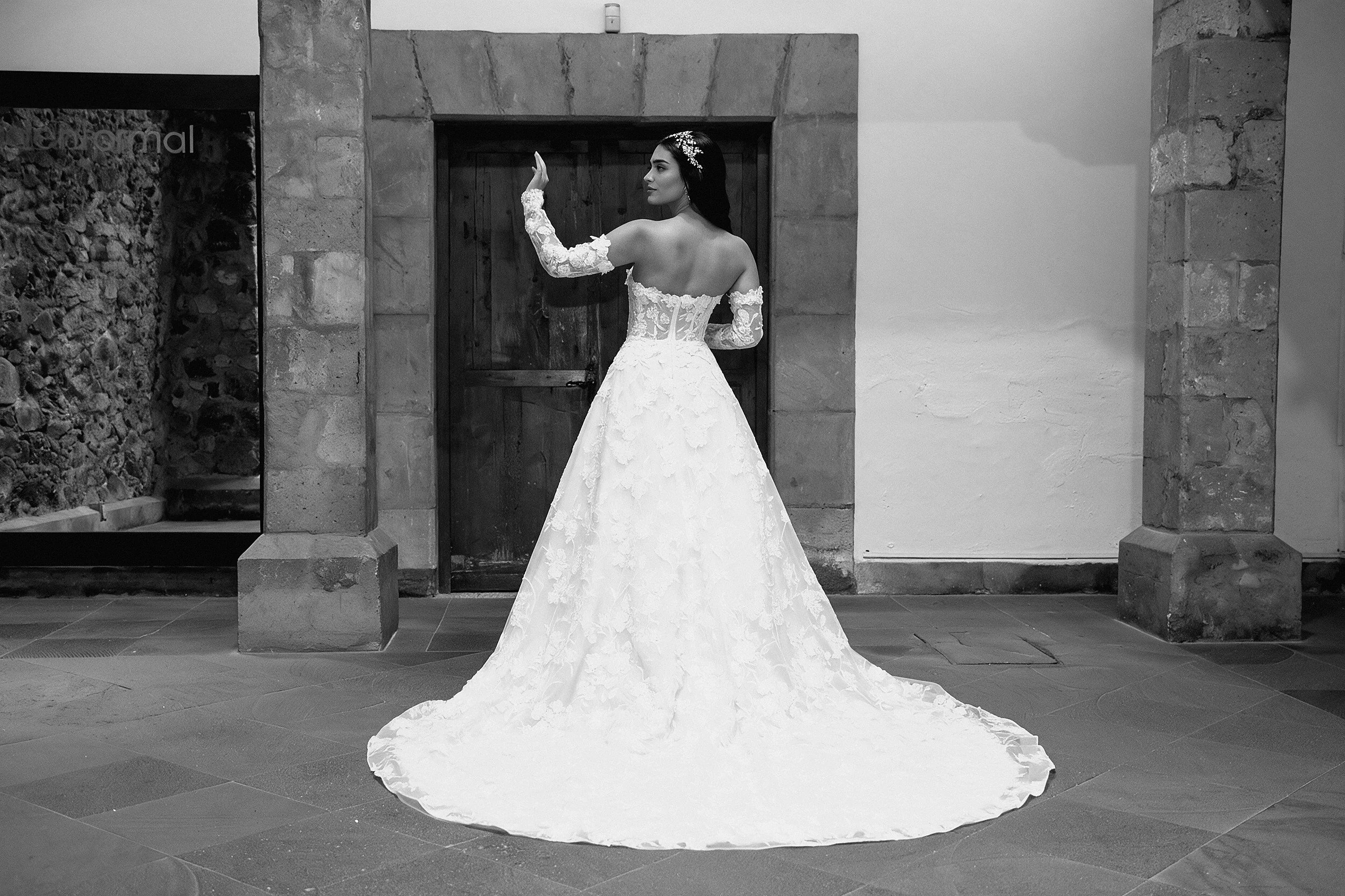 Vista de tres cuartos de la espalda del vestido Lucas con la cola extendida.
