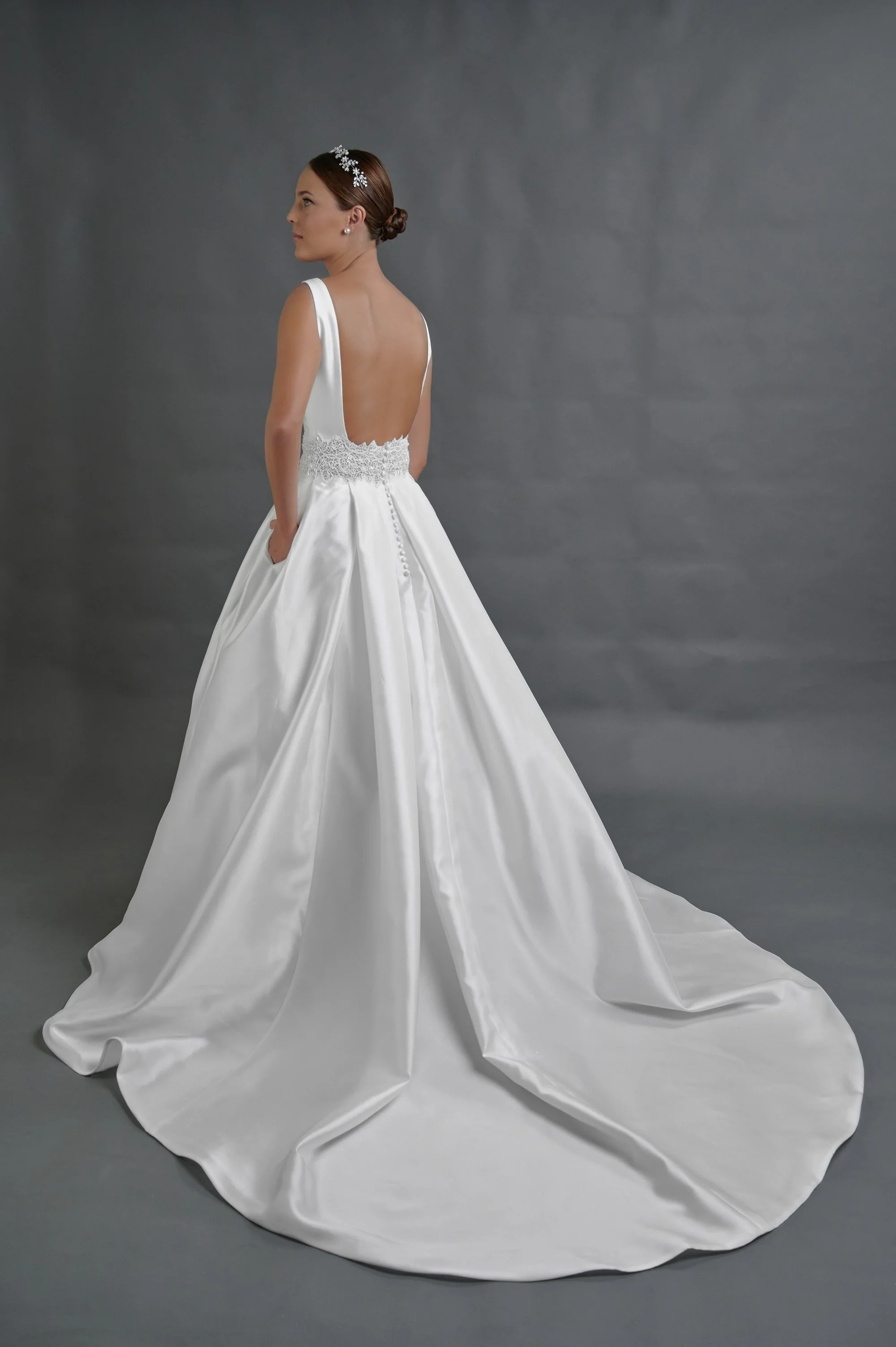 Vista lateral del vestido de novia Quintana mostrando el bolsillo y la caída del satén.