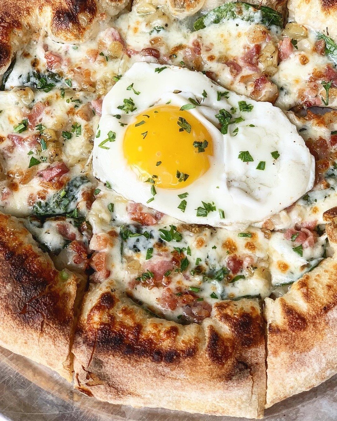&quot;Rise and dine with our delectable Early Bird Pizza at Pryor's Pizza Kitchen! 🍳🍕 Indulge in a symphony of flavors with creamy white sauce, gooey mozzarella, crisp bacon, vibrant spinach, savory roasted garlic, and a perfectly sunny-side-up egg